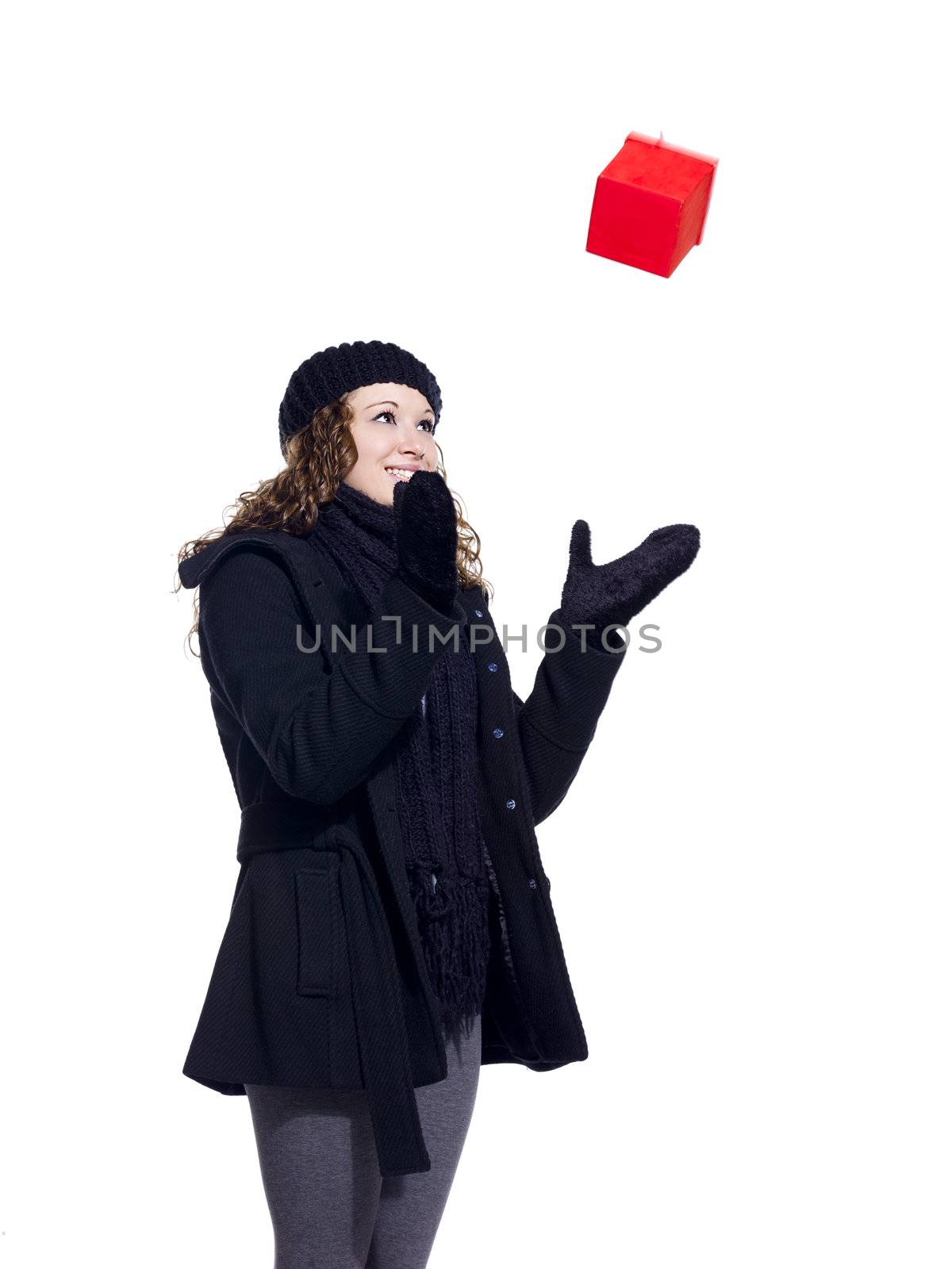 Cheerful young woman playing with her Christmas present over white background, Model: Brittany Beaudoin