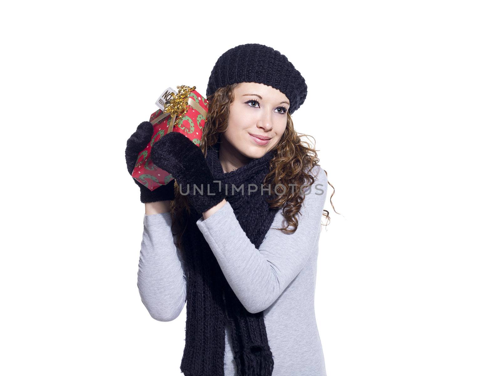 Beautiful young lady with Christmas present looking away over white background, Model: Brittany Beaudoin