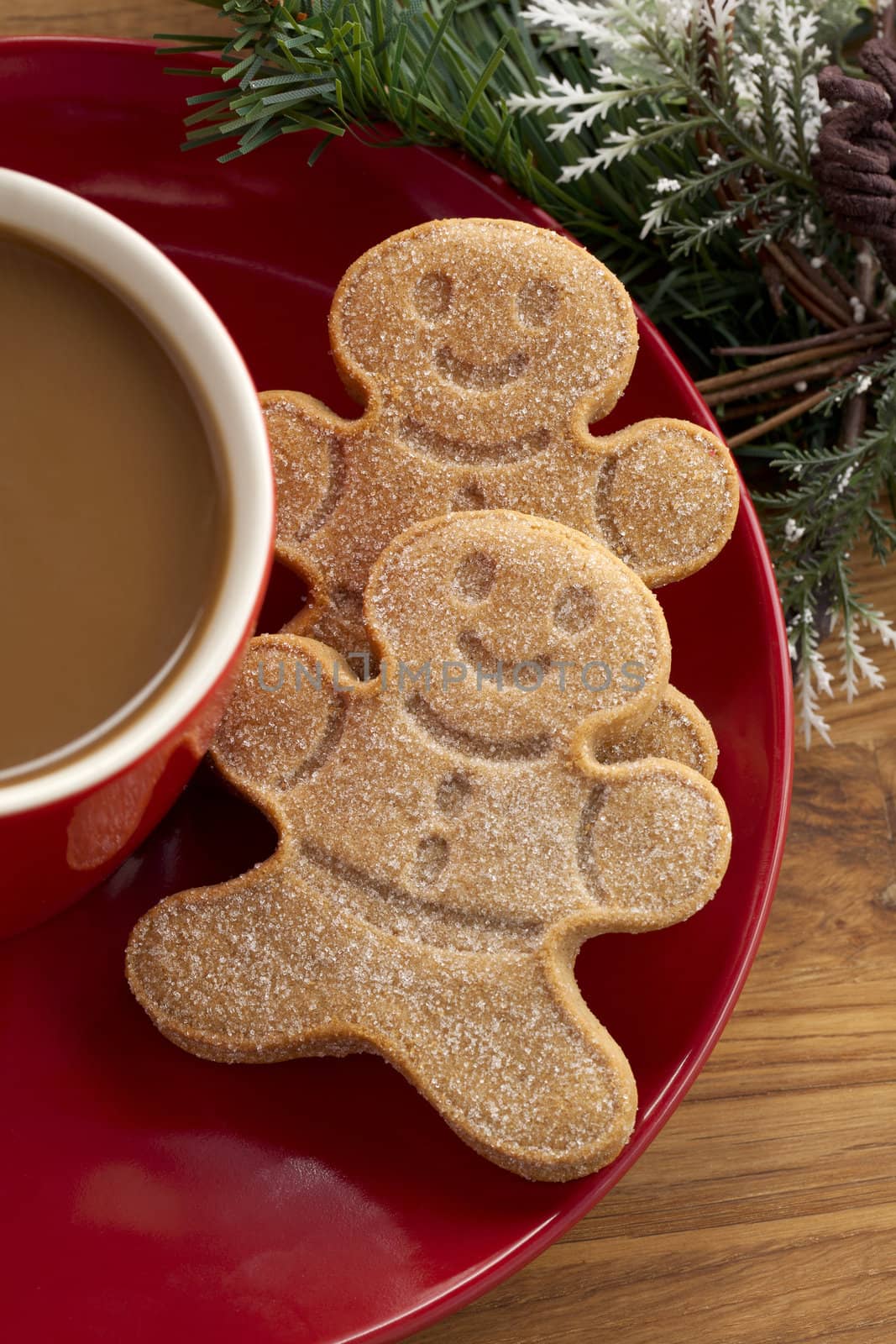 Cropped image gingerbread cookies in red saucer with coffee cup.