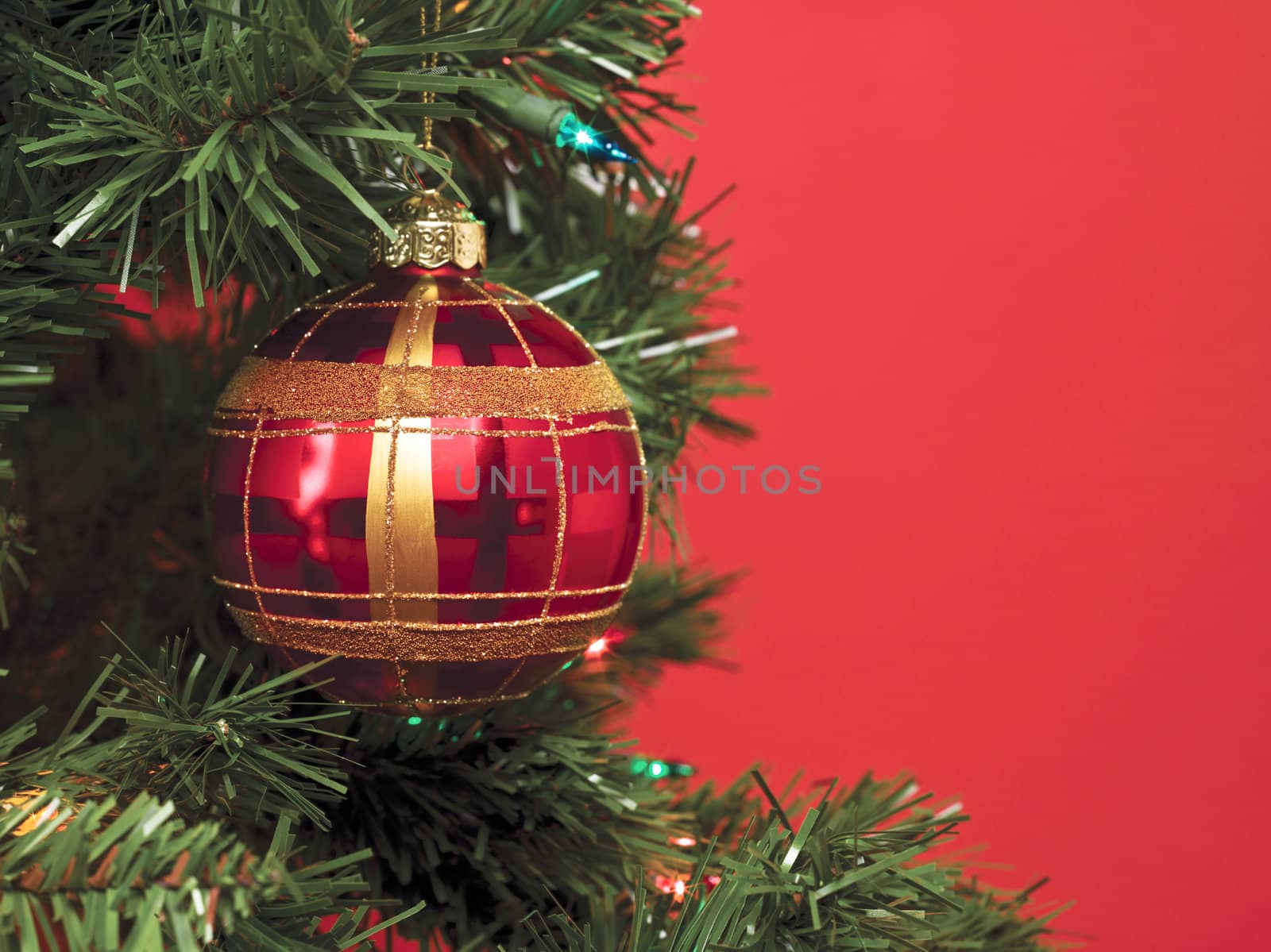 A close-up image of Christmas ball over the Christmas tree isolated on a red background 