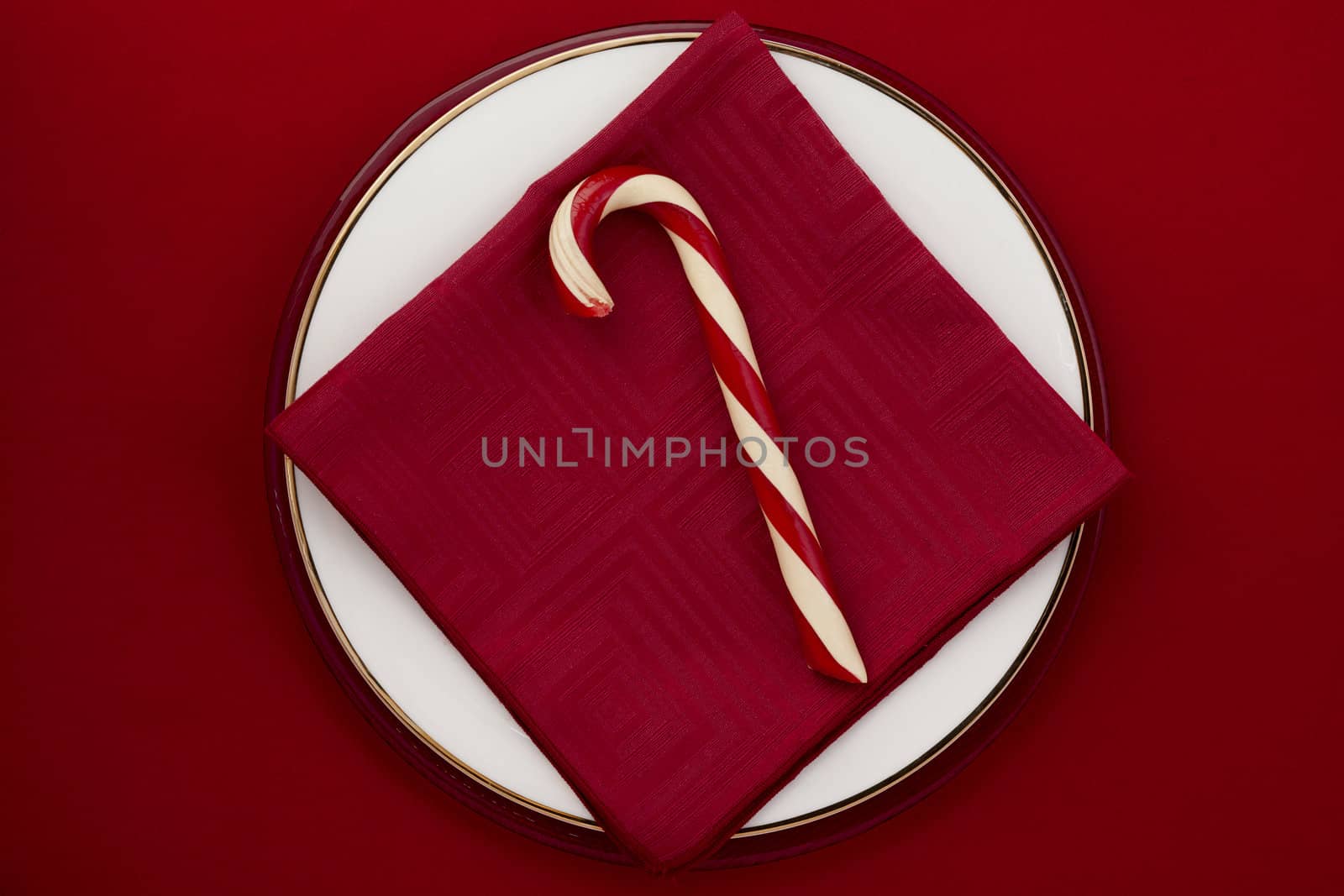 A top view image of sweet candy cane over the red background