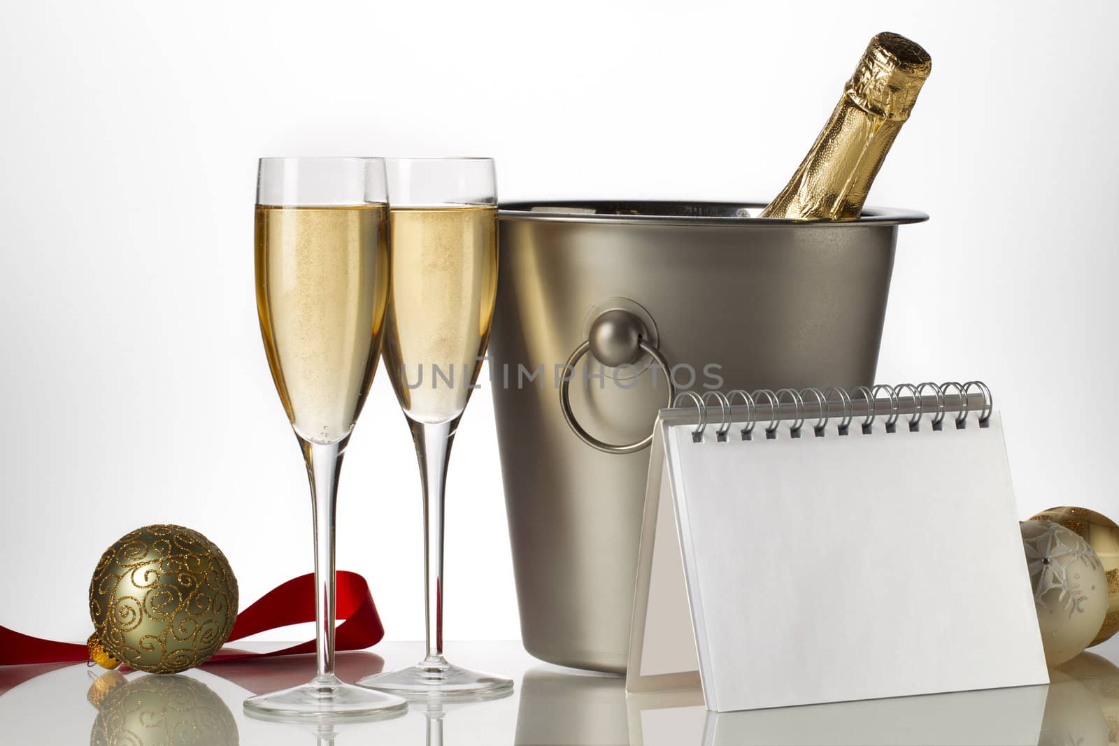 champagne bottle flutes and ice bucket with christmas baubles by kozzi