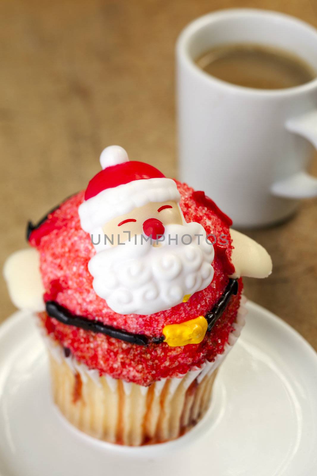 Close-up of decorated christmas cupcake with coffee in background