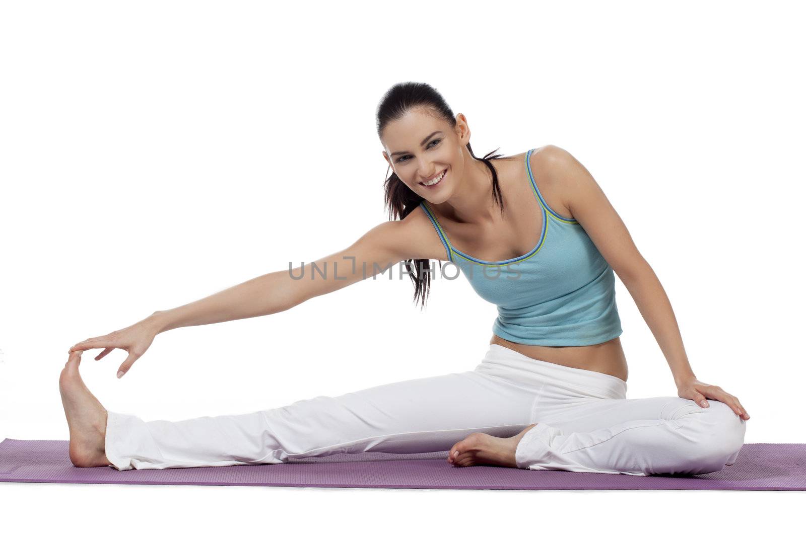 Portrait of smiling young woman stretches her leg on a white background