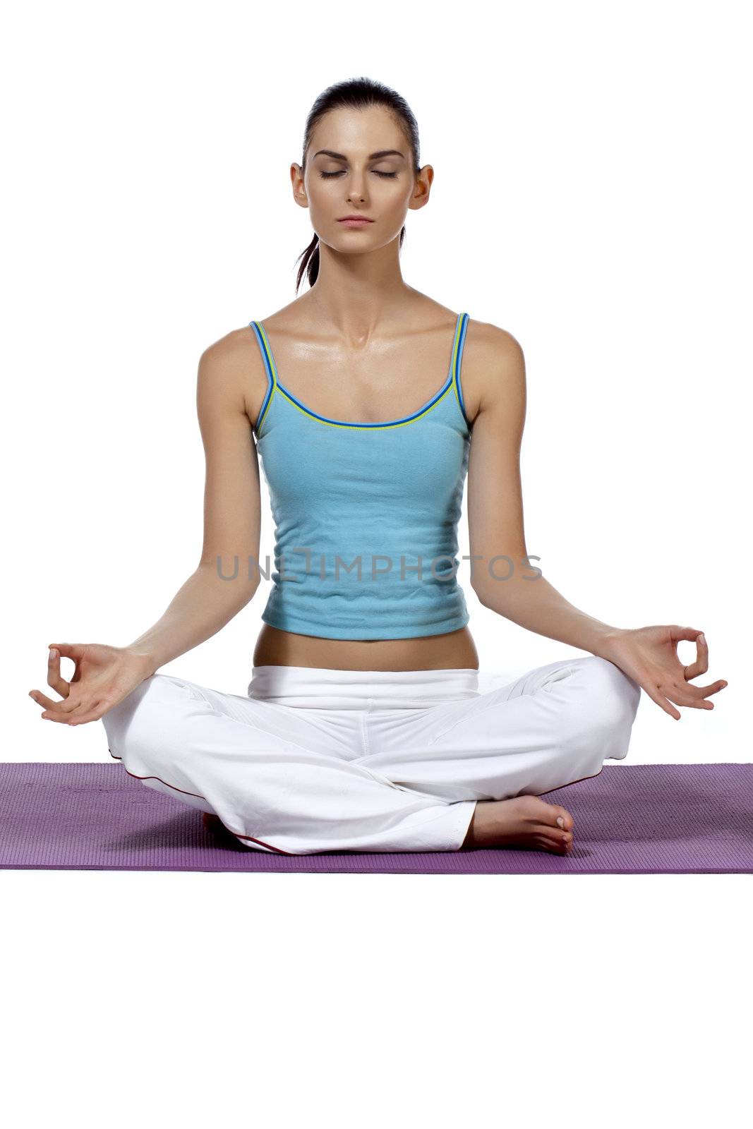 Close-up image of a beautiful lady meditating over the mat