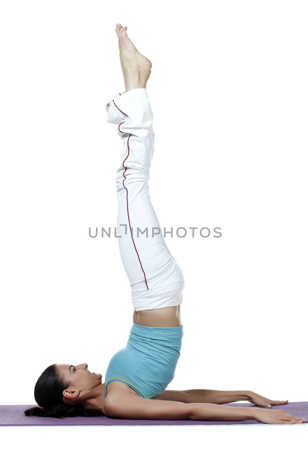 Young woman doing the shoulder stand in yoga exercise isolated in a white background 