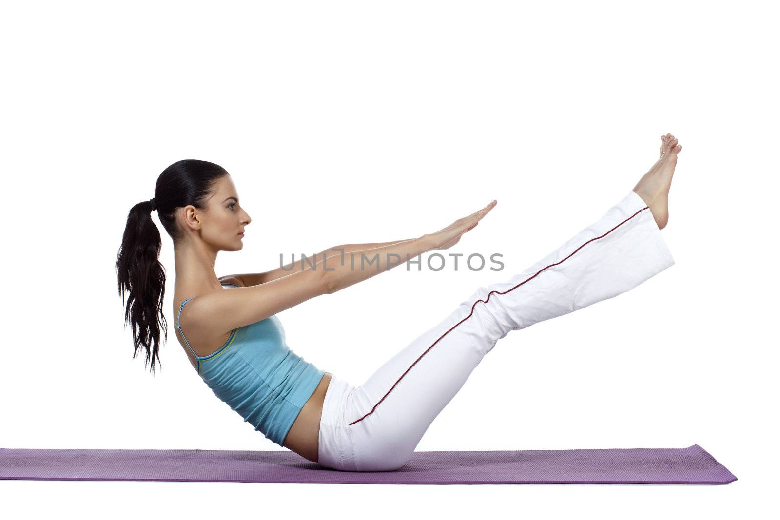 Horizontal image of a sporty woman stretching her legs and arms while lying on the mat