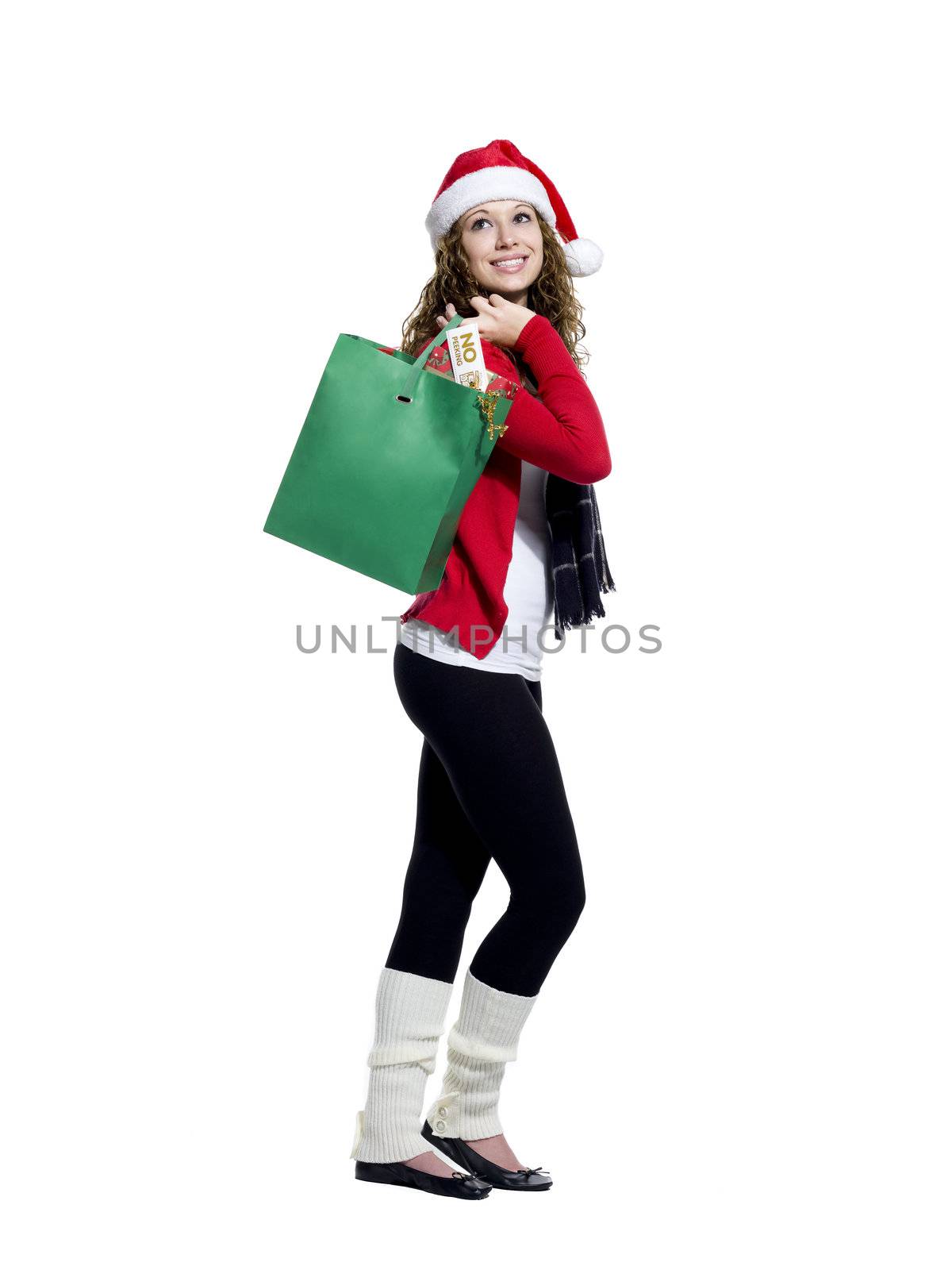 Side view of a young woman with shopping bags looking away while standing over white background, Model: Brittany Beaudoin