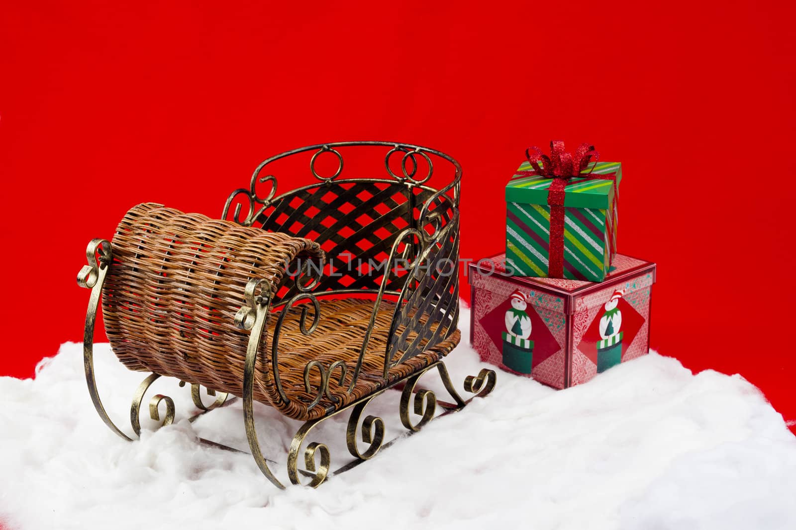 gifts on the snow beside wicker sleigh by kozzi