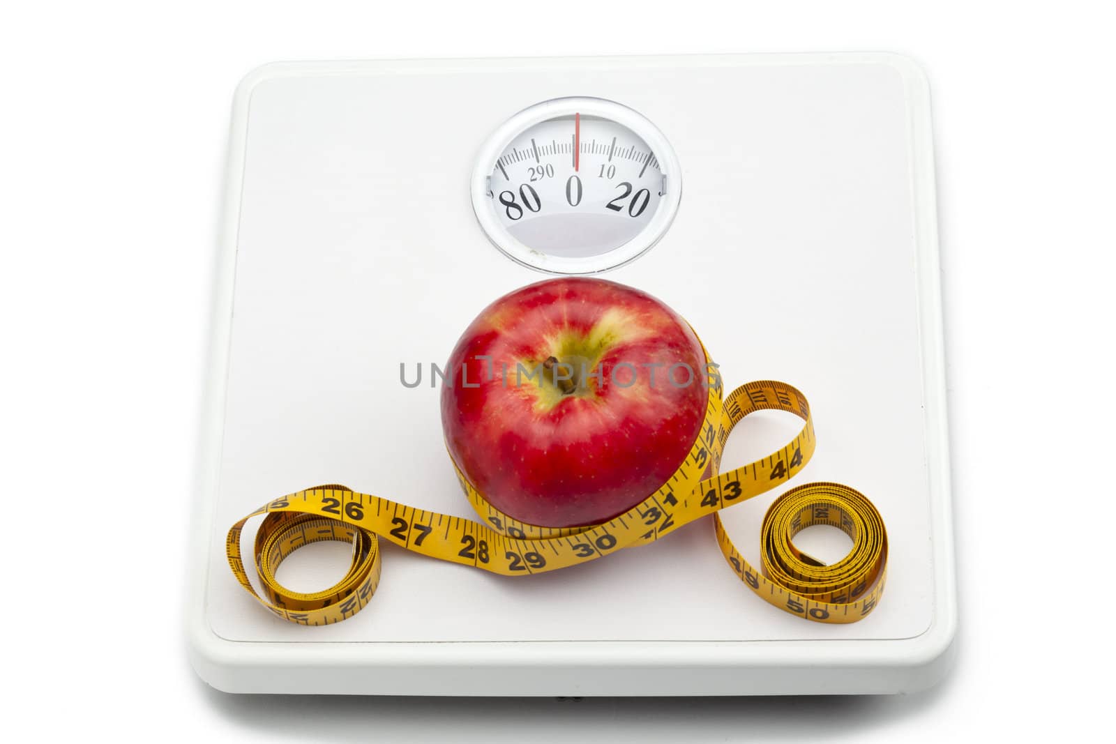 Red apple and measuring tape on the weighing scale