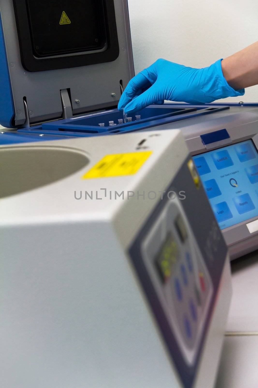 Research scientist putting test tube into real-time pcr machine by ponsulak