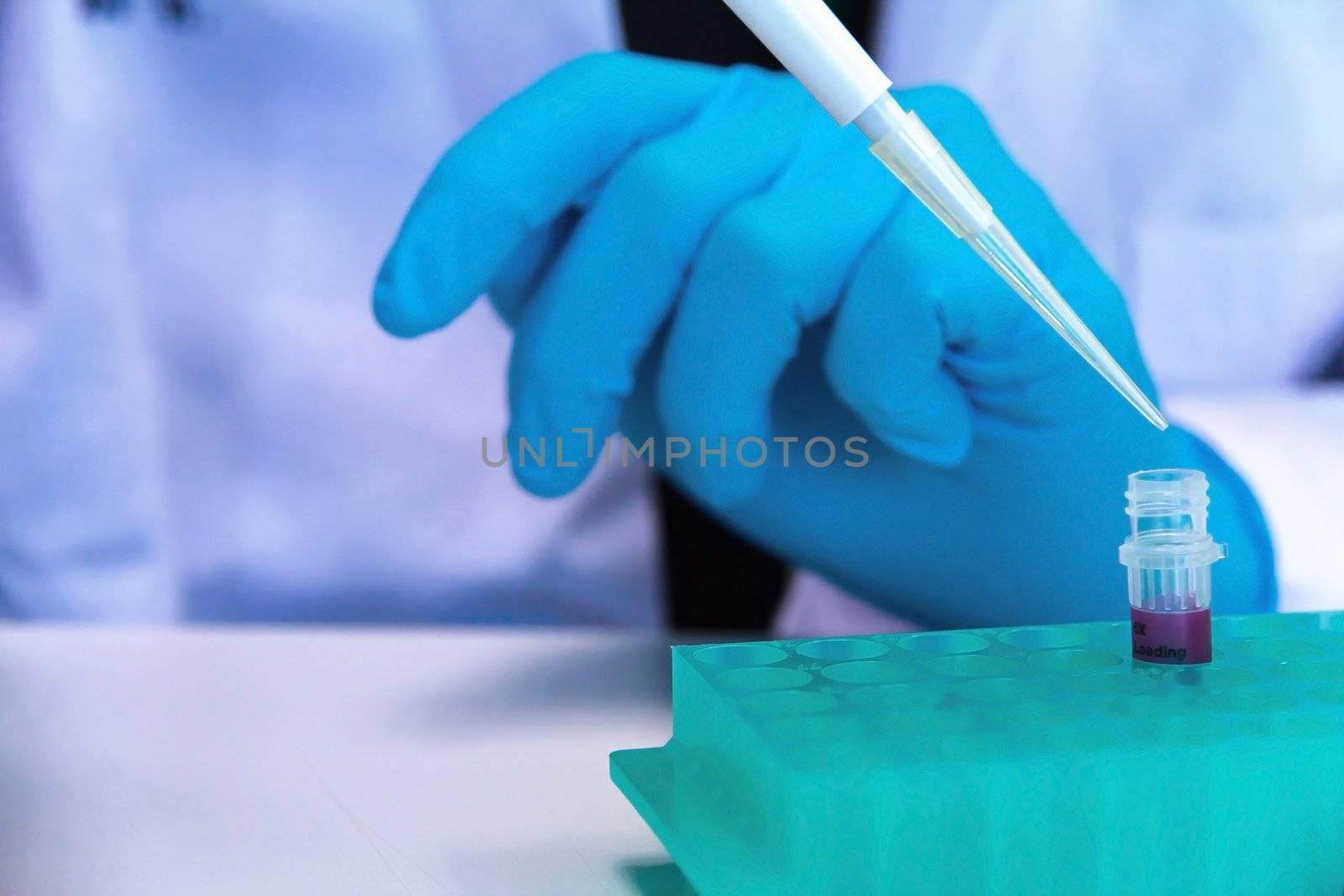 Pipette with drop of liquid in a science research lab by ponsulak