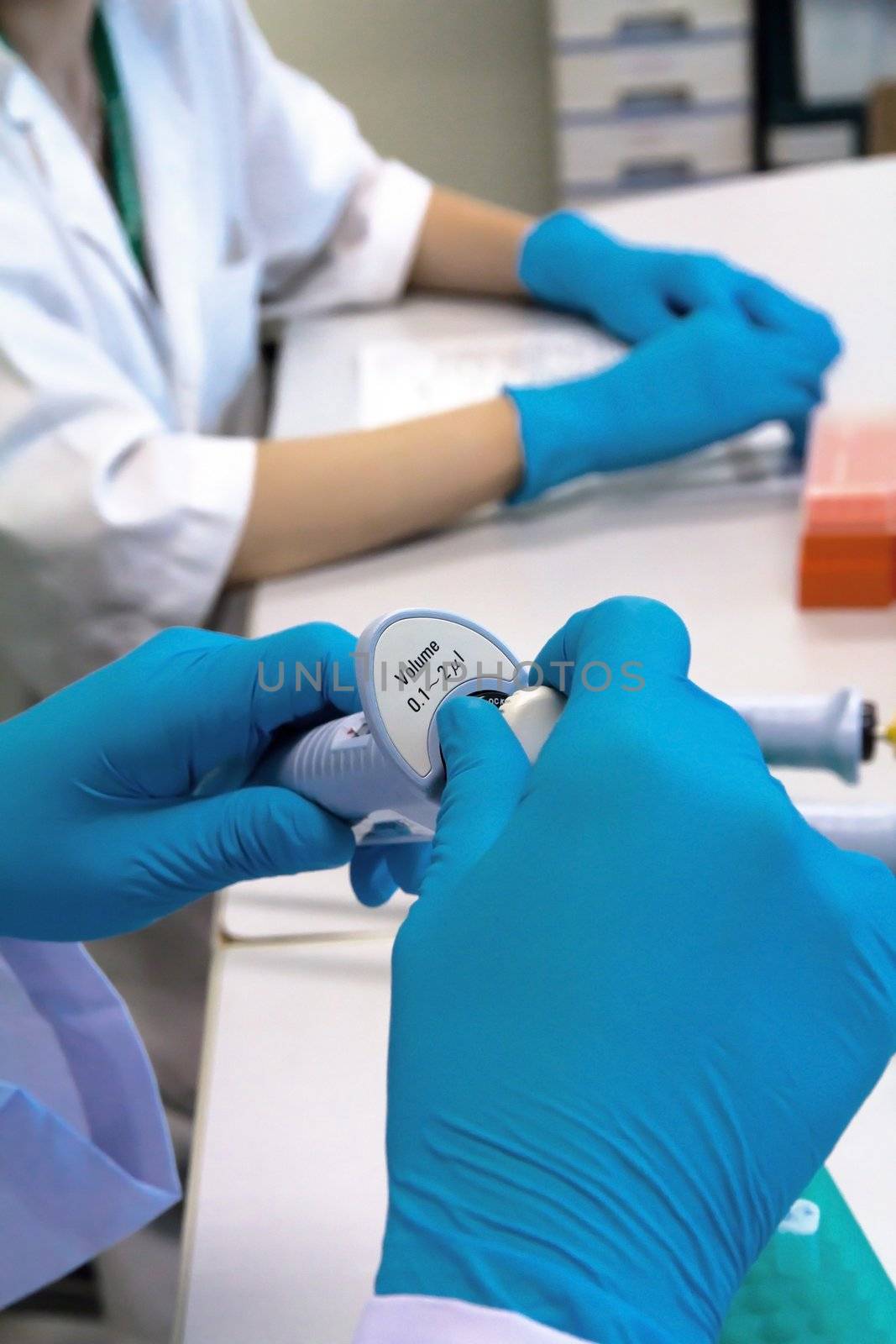 researcher holding pipette in a science research lab by ponsulak