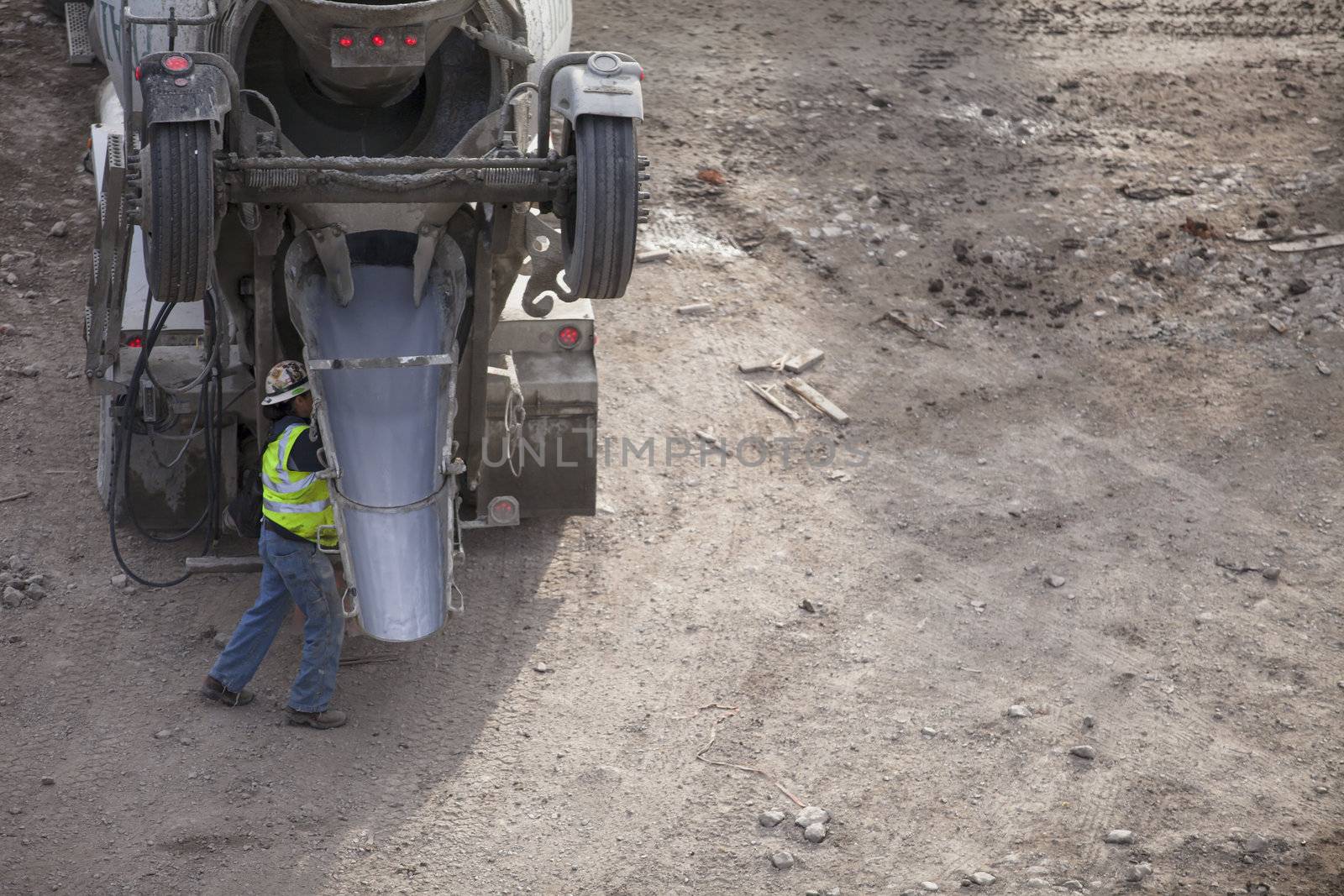 Cropped image of cement mixer truck and a worker in a construction site