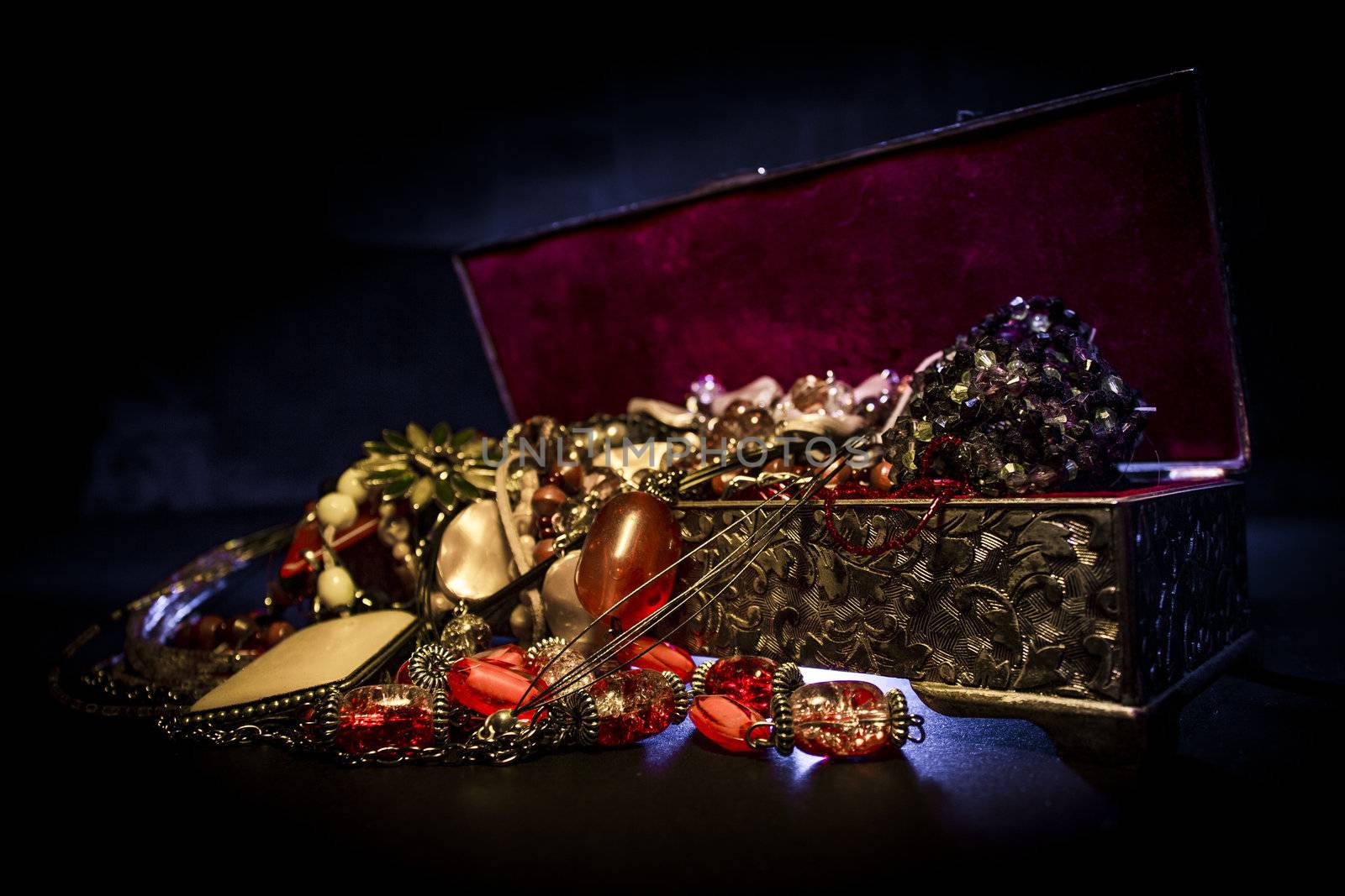 Silver treasure box in the dark, full of necklaces and jewelery