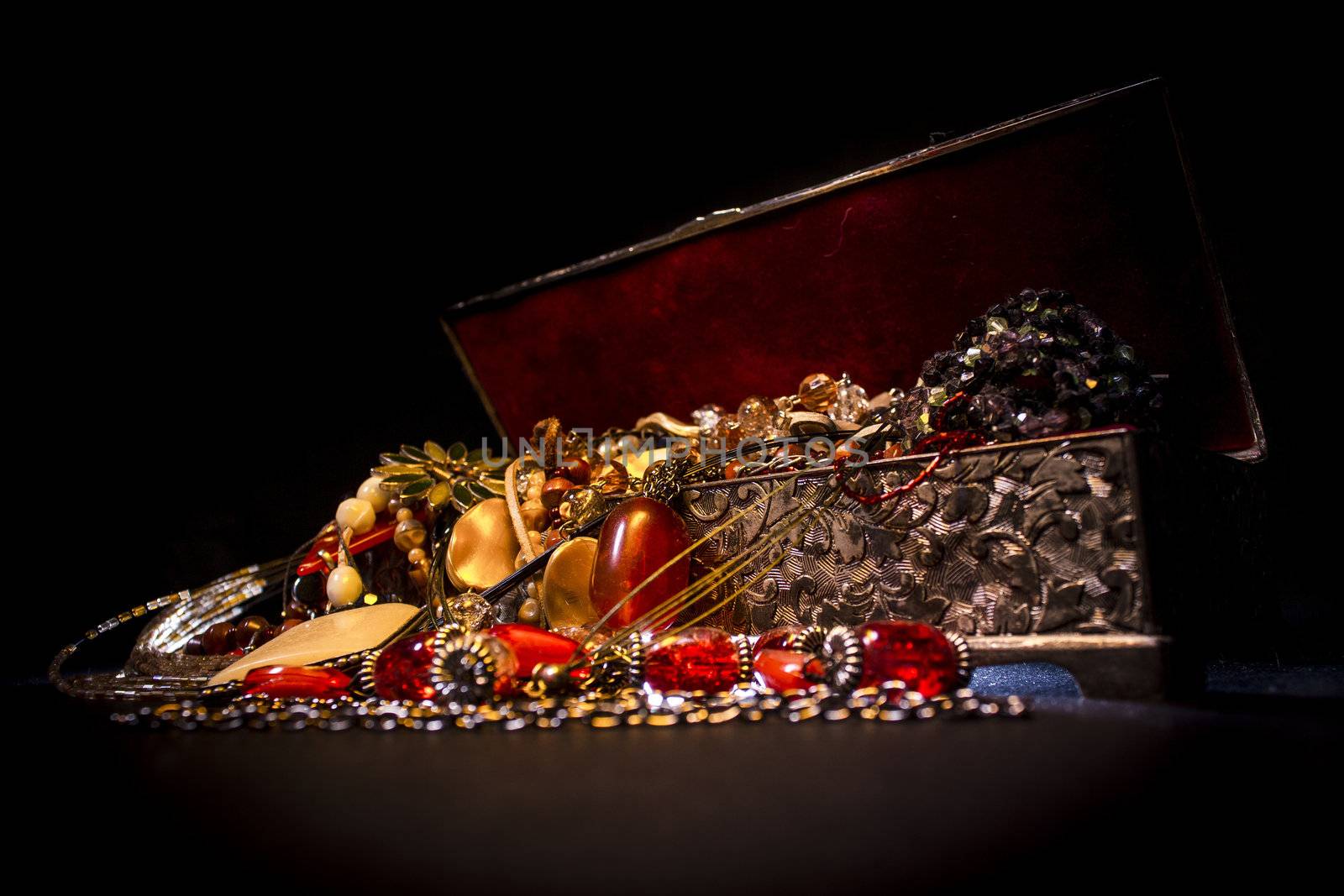 Silver treasure box in the dark, full of necklaces and jewelery