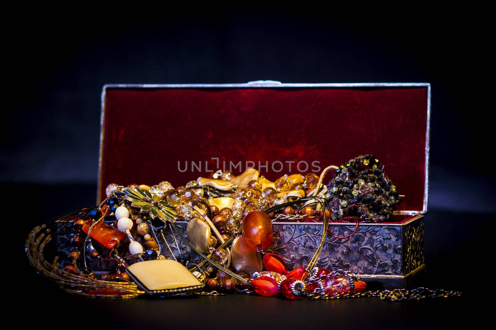 Silver treasure box in the dark, full of necklaces and jewelery