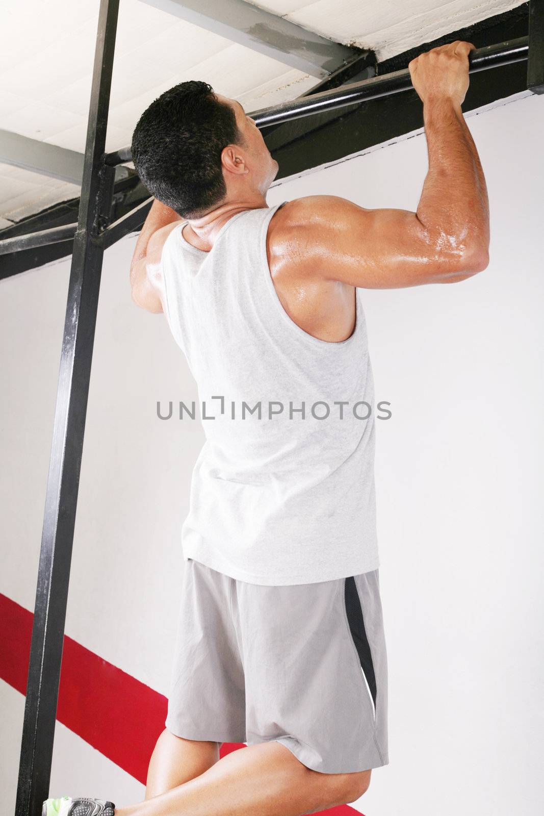 strong man performing pull ups in a bar by dacasdo