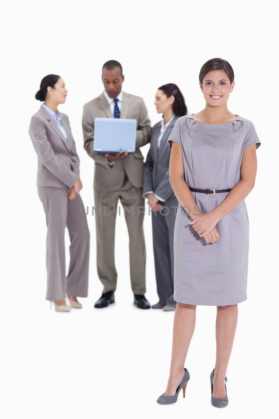Woman holding her hands with co-workers talking with a laptop in the background