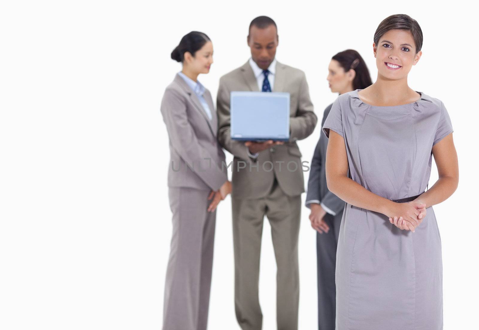 Woman welcoming and co-workers with a laptop in the background by Wavebreakmedia