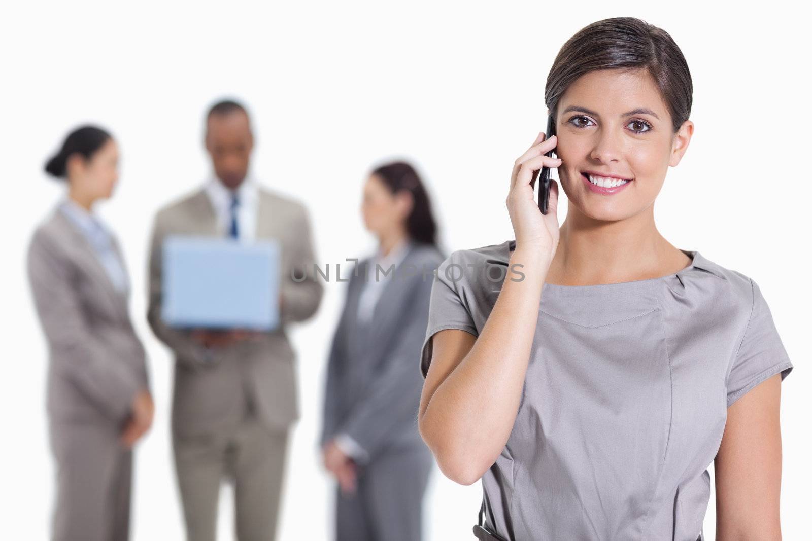Close-up of a woman smiling on the phone and co-workers with a l by Wavebreakmedia