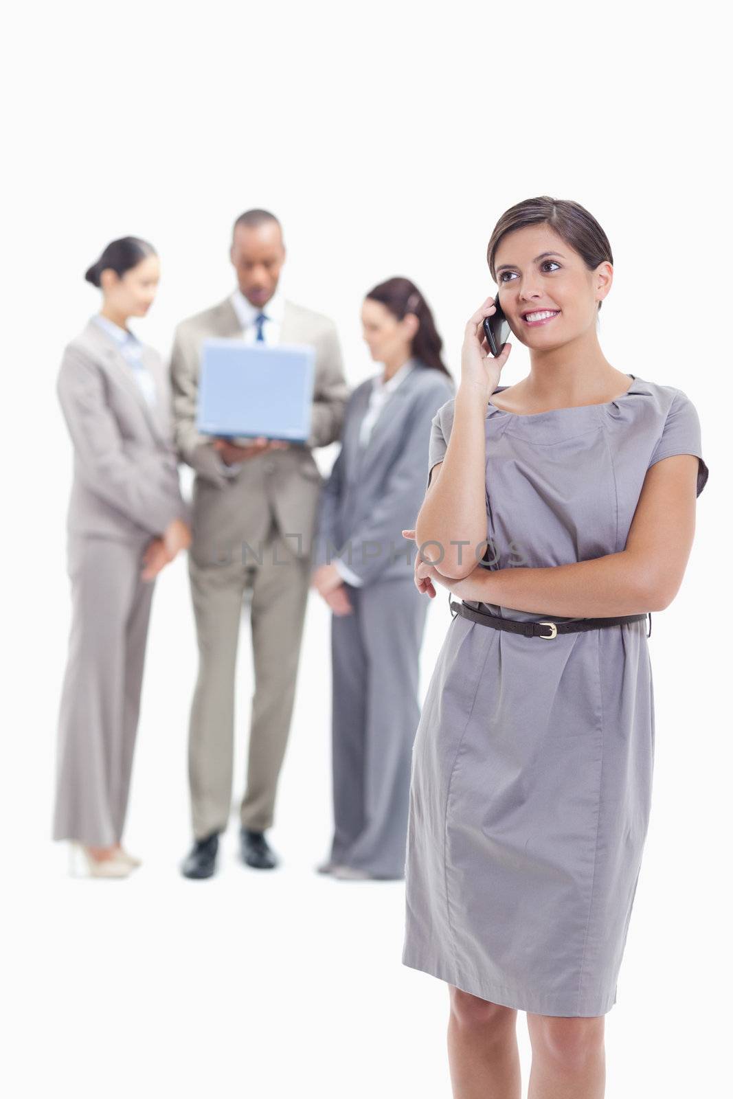 Businesswoman looking up on the phone with co-workers in the bac by Wavebreakmedia
