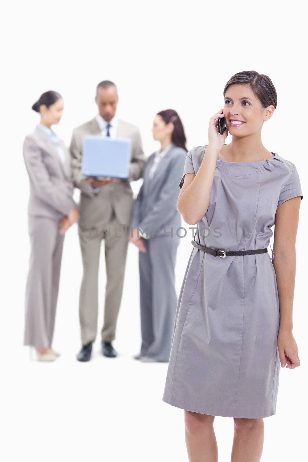 Businesswoman smiling on the phone with one arm along her body a by Wavebreakmedia