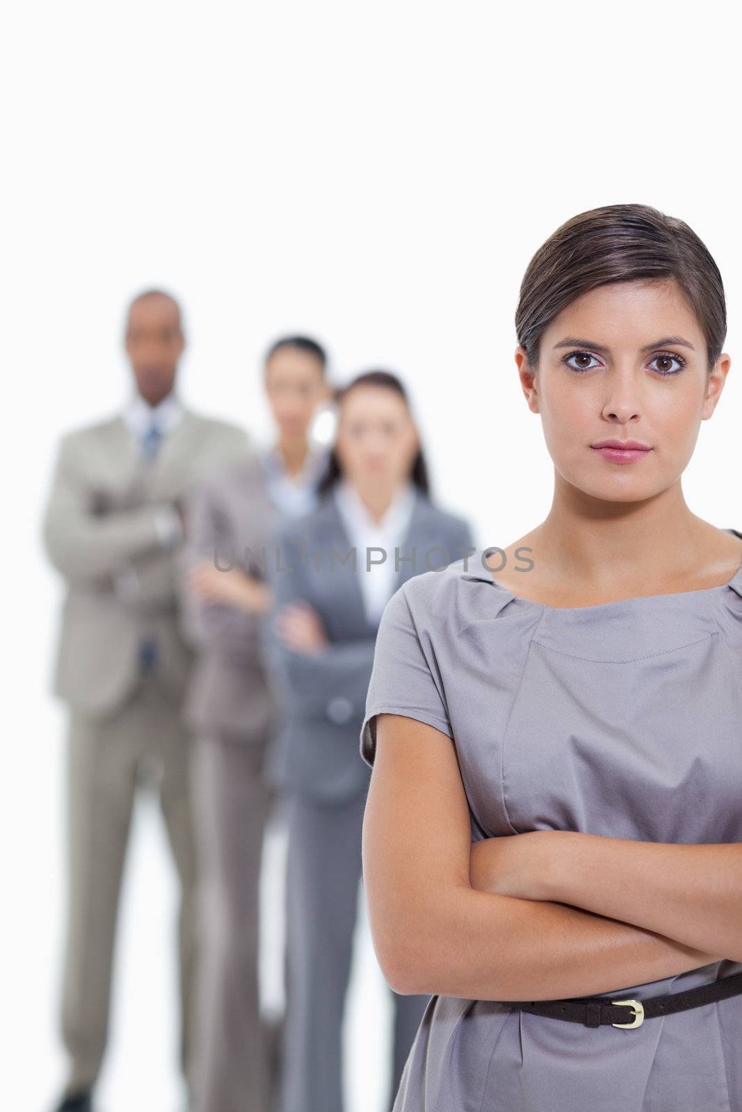 Close-up of a business team crossing their arms and standing behind each other with focus on the foreground woman against white background