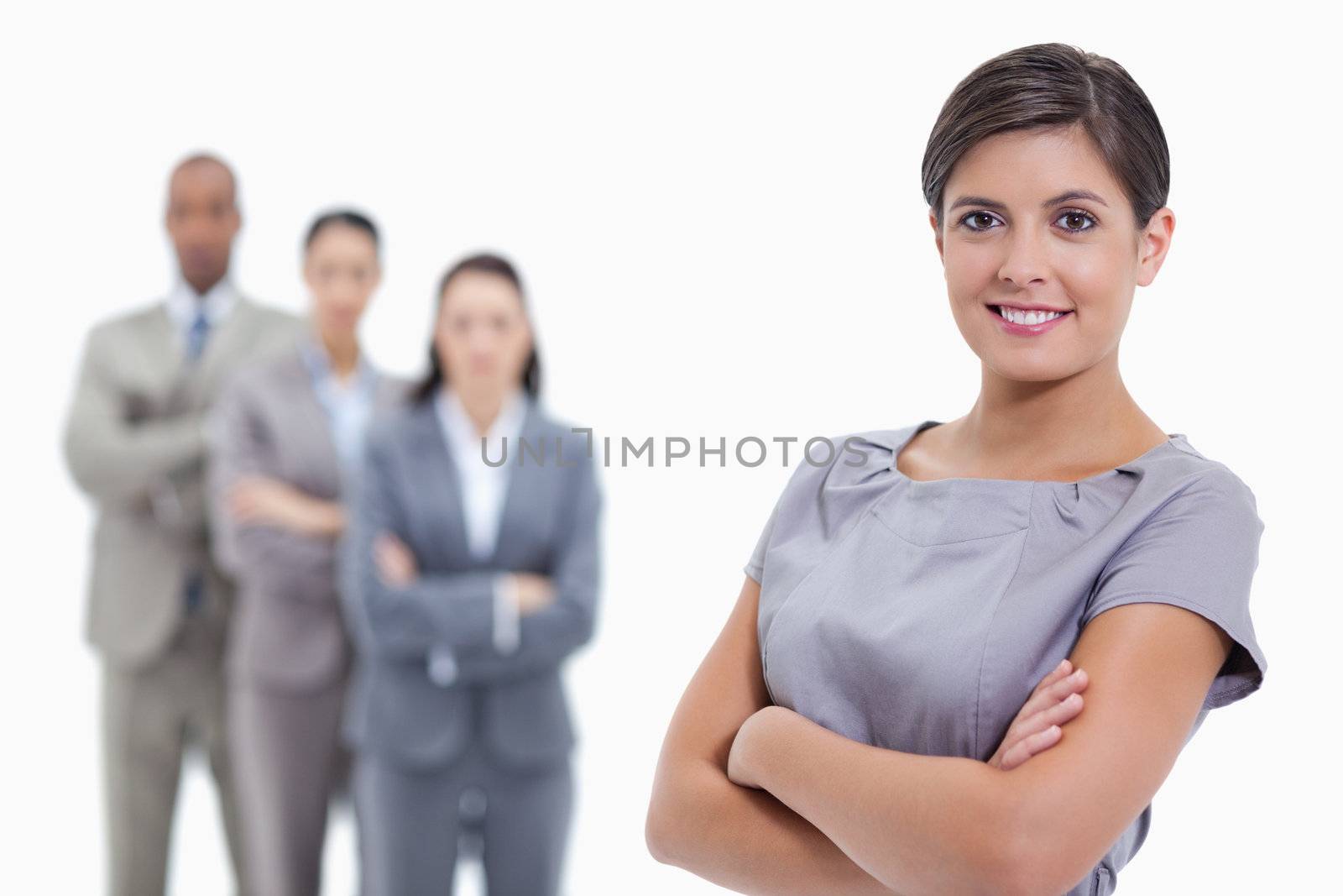 Close-up of a businesswoman smiling and a team crossing their ar by Wavebreakmedia