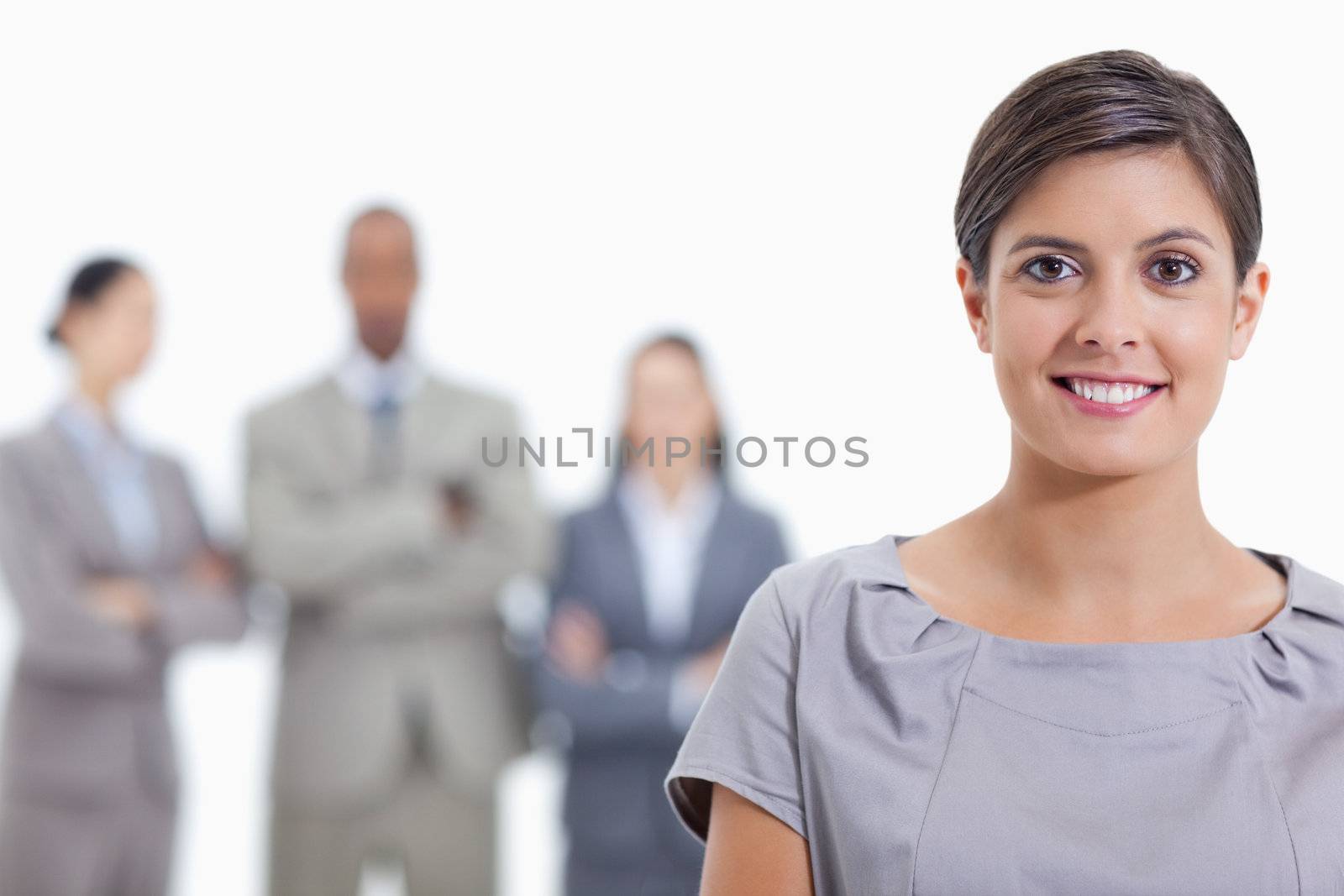 Big close-up of a businesswoman smiling and a team in background by Wavebreakmedia