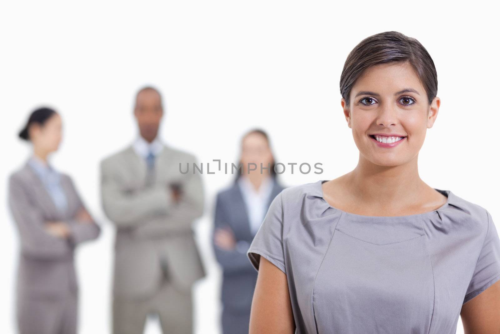 Close-up of a businesswoman smiling and a team in background by Wavebreakmedia