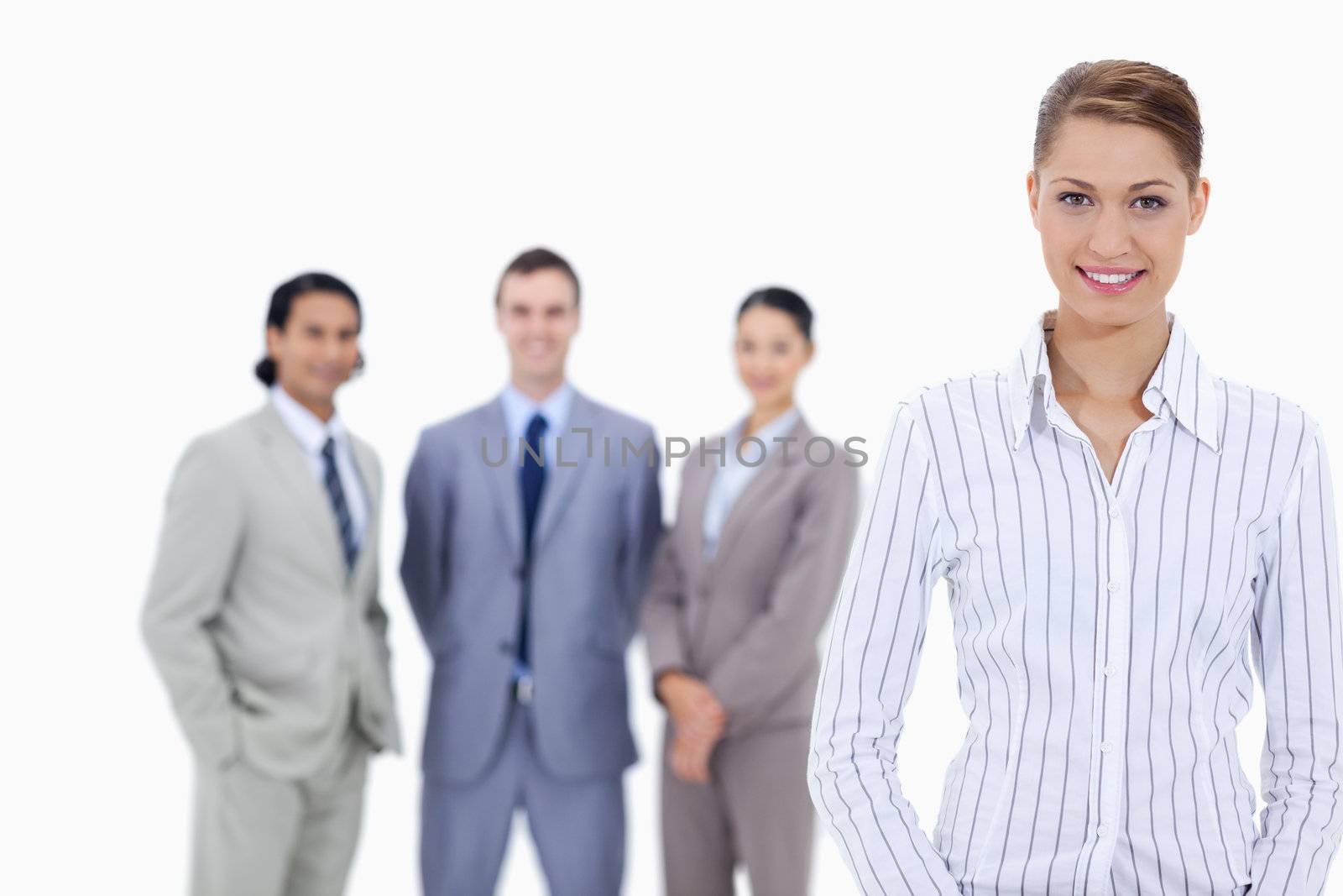 Secretary smiling with business people in background by Wavebreakmedia