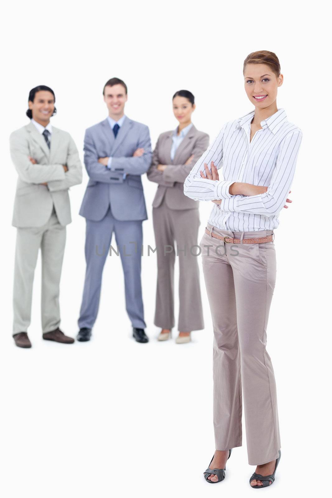 Secretary smiling and crossing her arms with happy business people behind her against white background