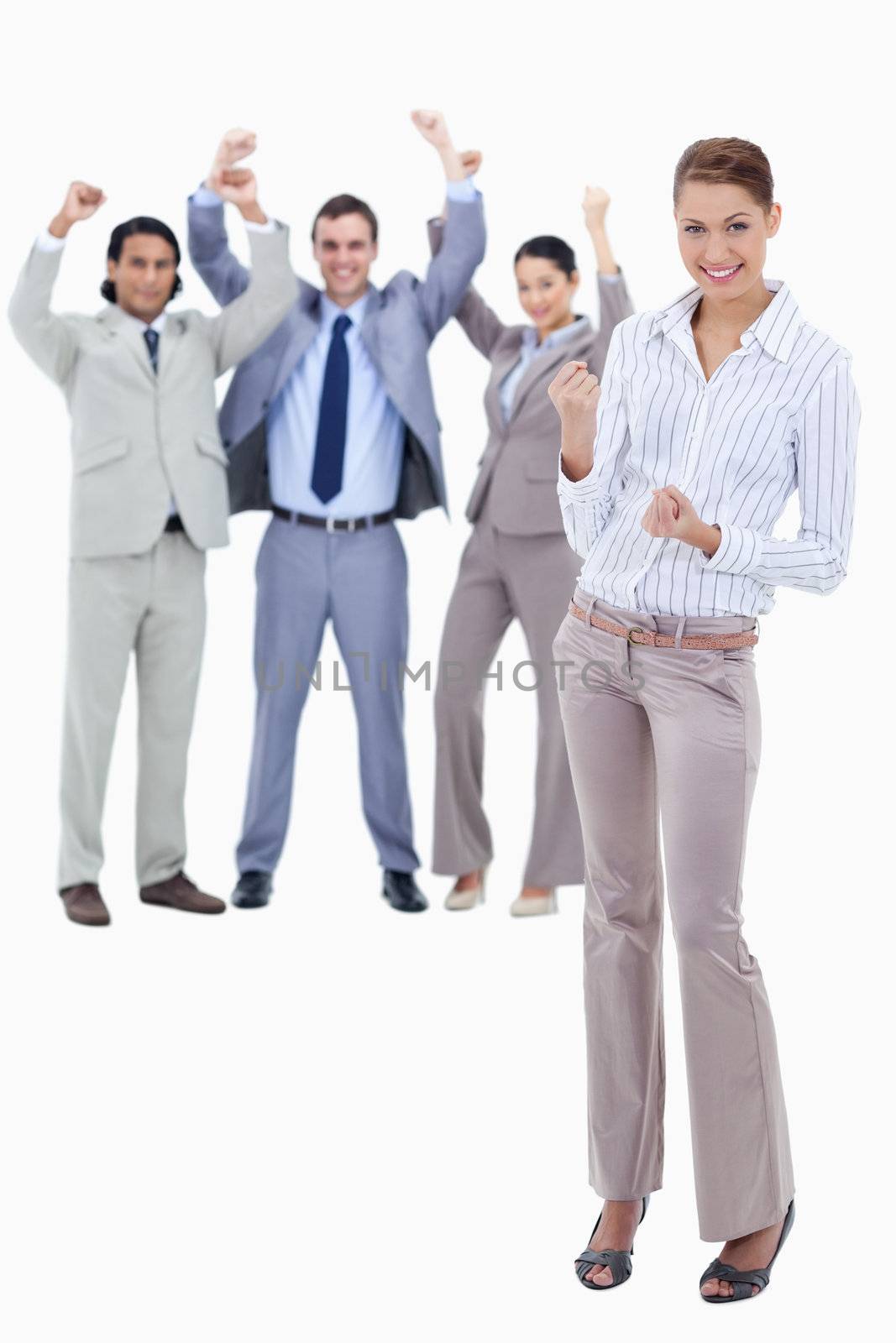 Secretary smiling and clenching her fists with very enthusiastic business people behind her against white background