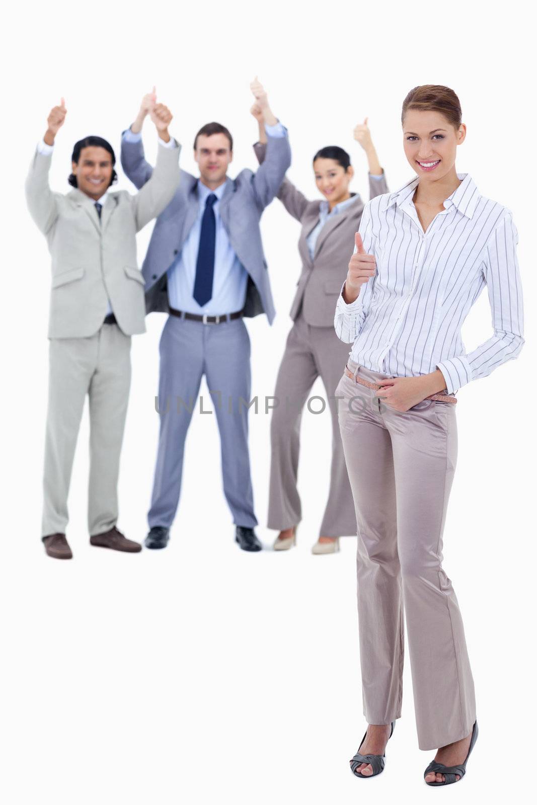 Secretary in foreground and business people with their thumbs up by Wavebreakmedia