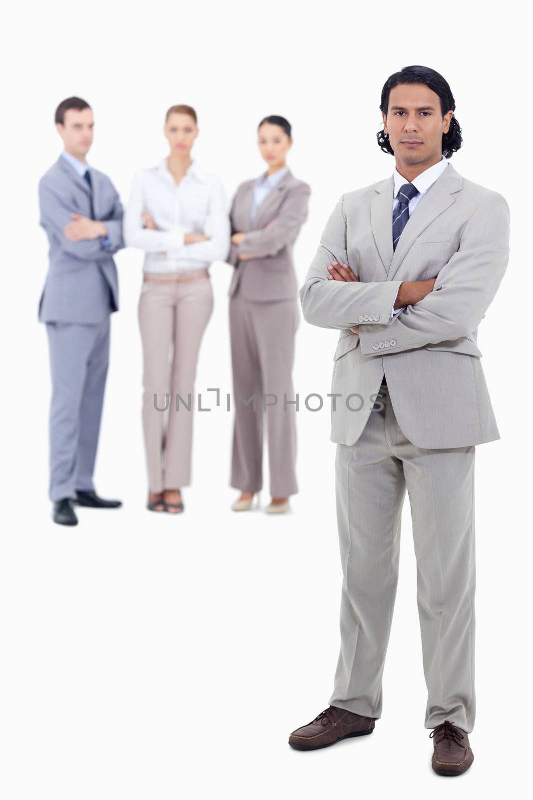 Businessman crossing his arms with serious people in background against white background