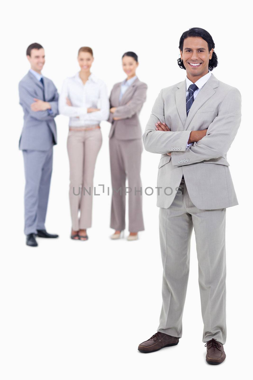 Businessman smiling and crossing his arms with happy people behind him against white background