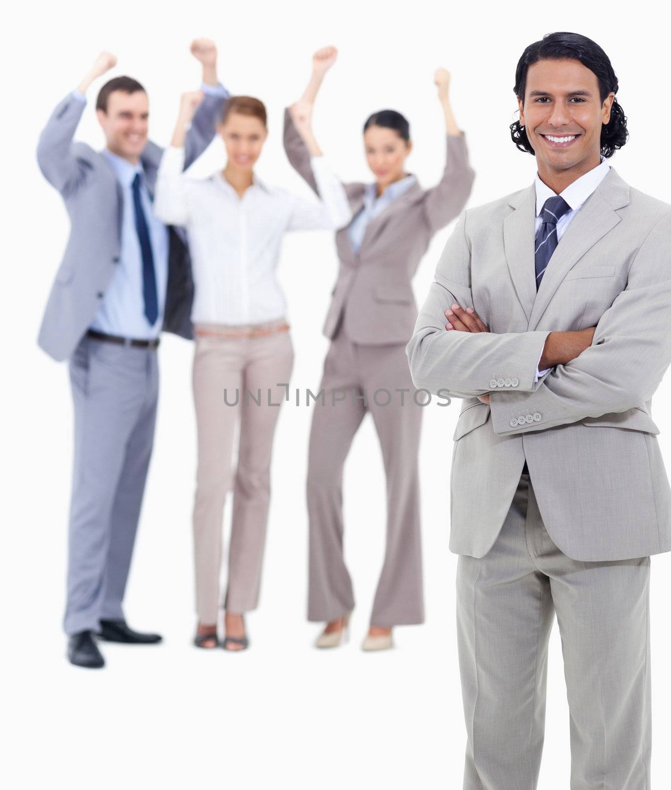 Small close-up of a businessman smiling and crossing his arms with enthusiastic people behind him against white background