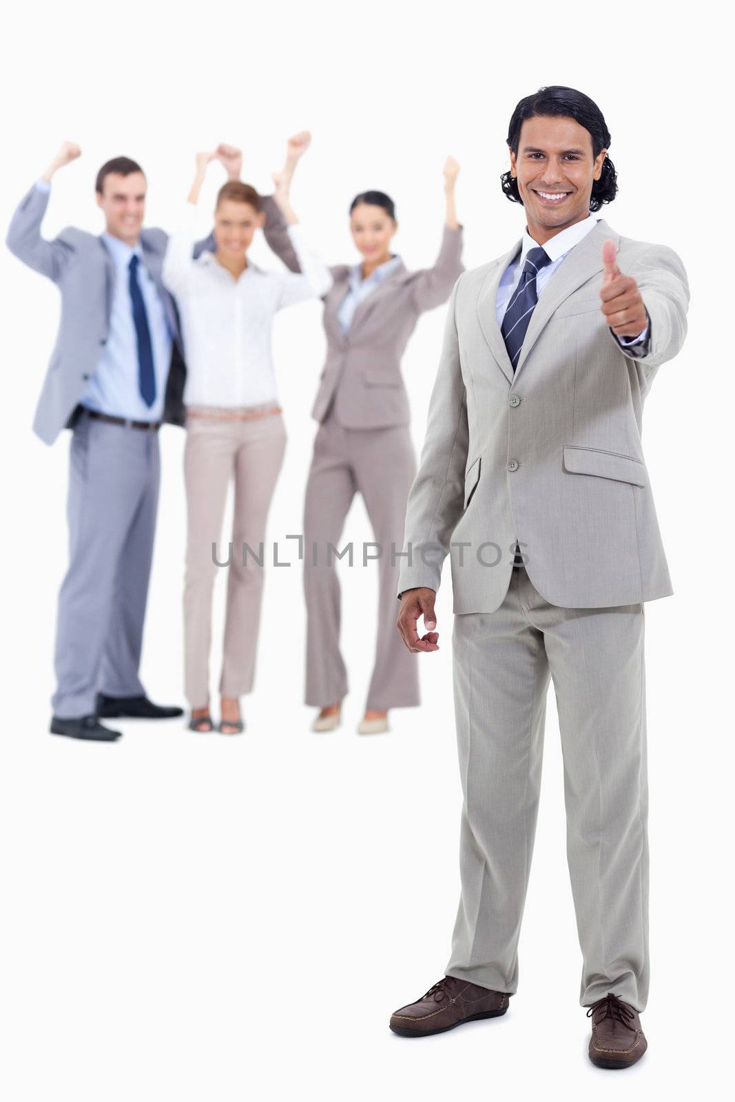 Businessman smiling with his thumbs up and cheering people behind him against white background