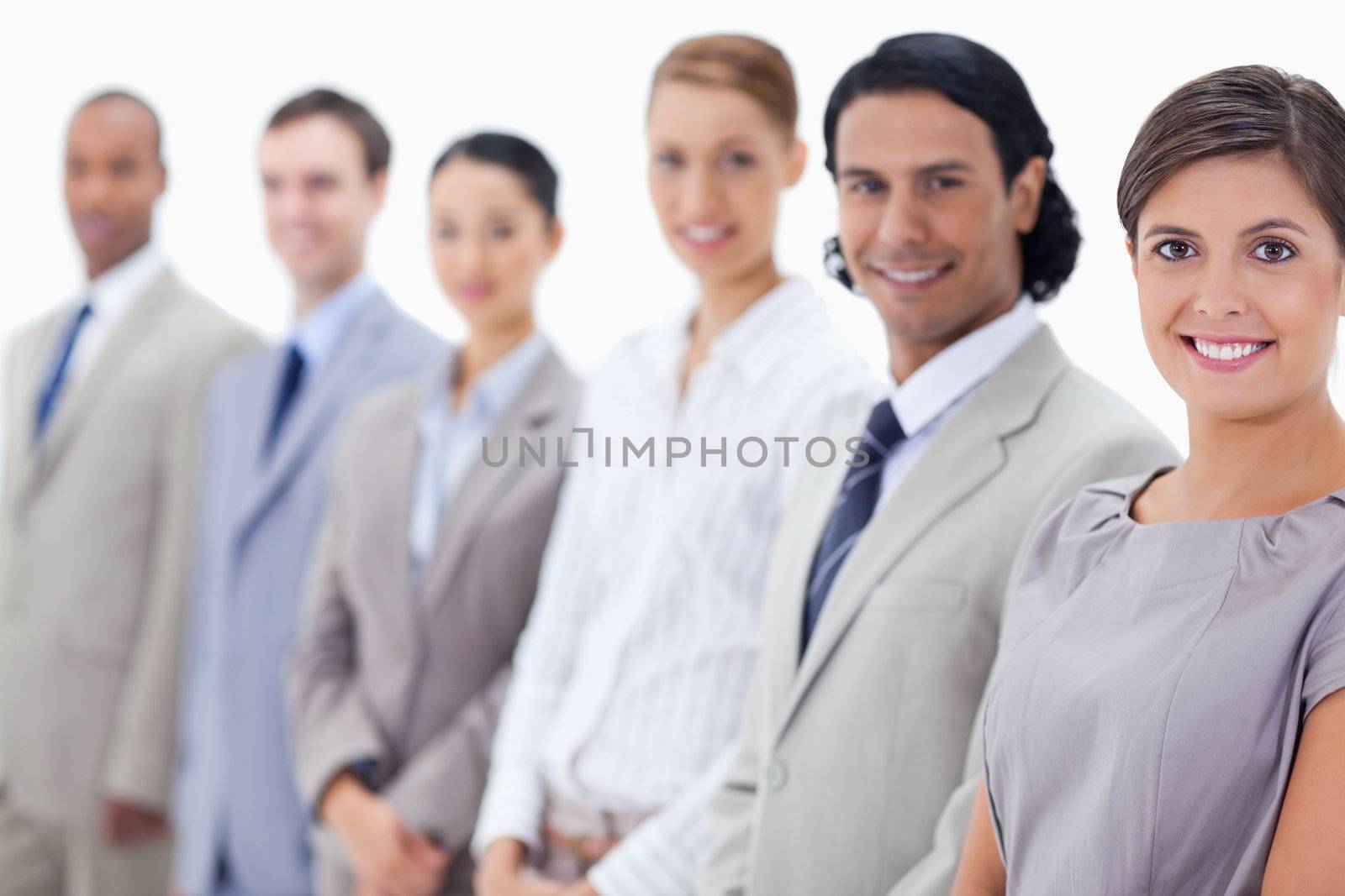 Close-up of a smiling business team looking straight with focus on the first woman
