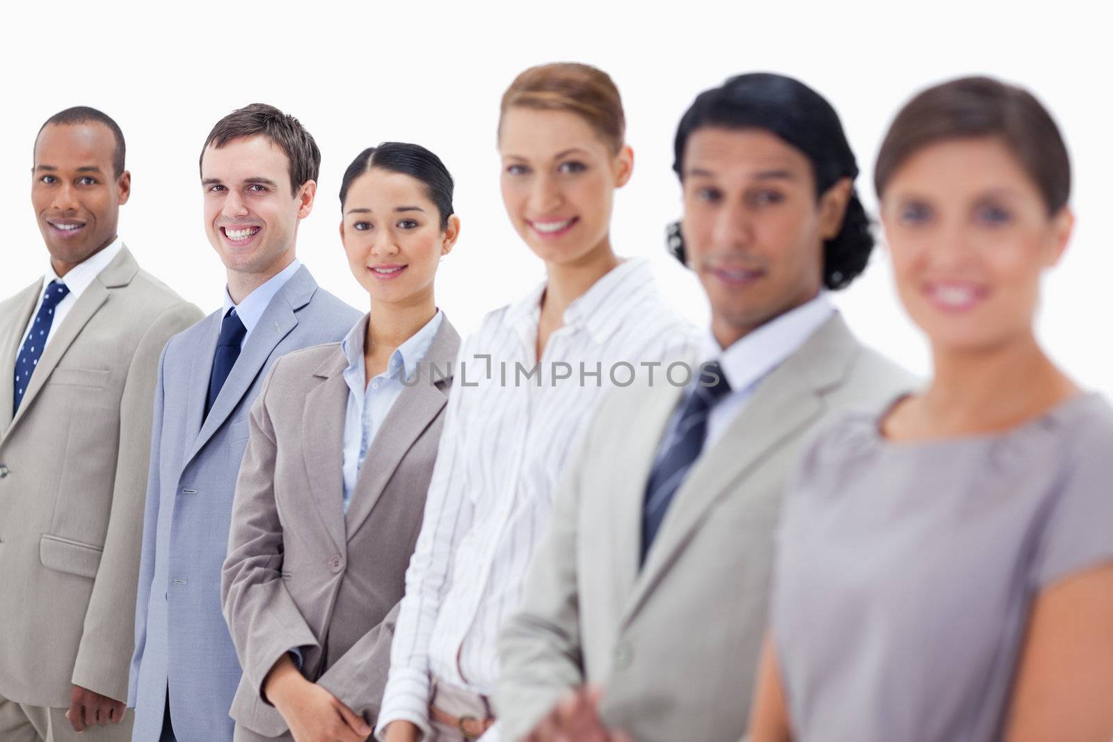 Close-up of business people smiling and looking straight with focus on the last three people