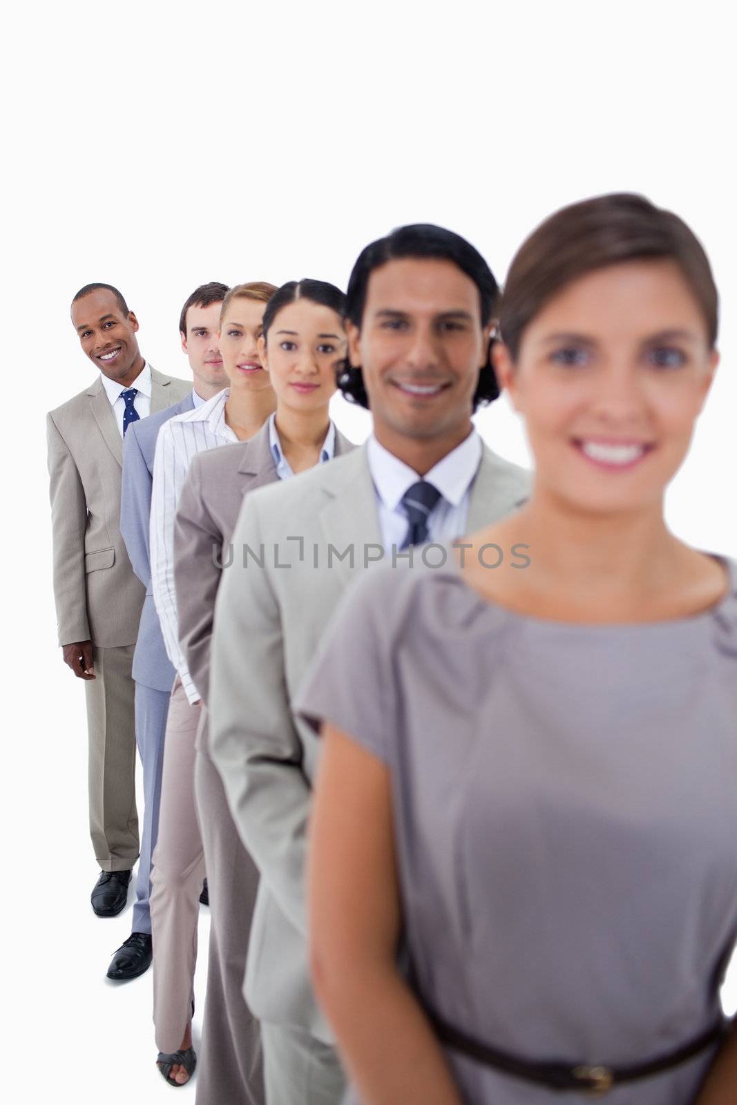 Close-up of workmates in a single line looking straight with focus on the last man against white background