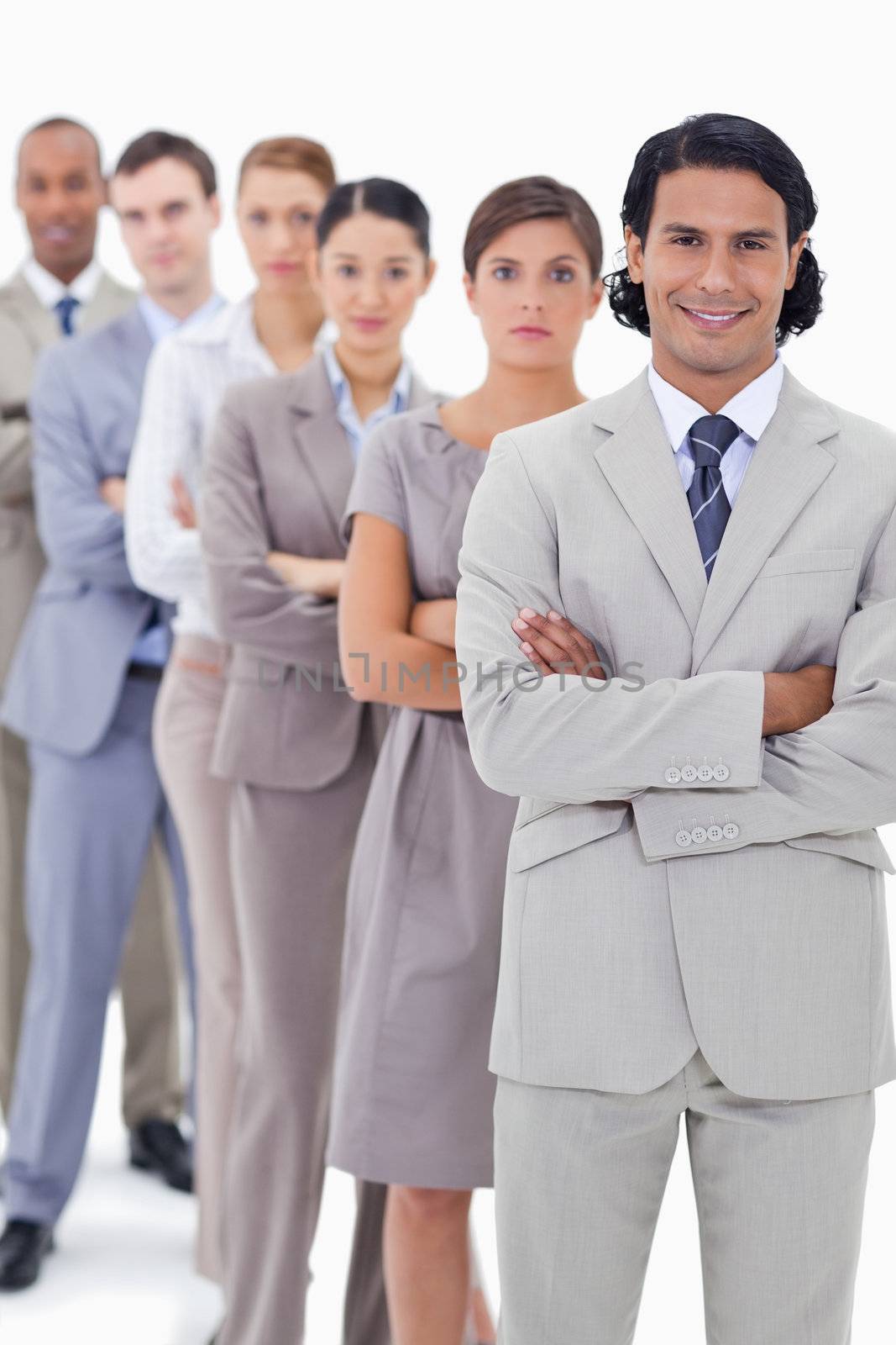 Close-up of a business team crossing their arms in a single line with focus on the first man smiling
