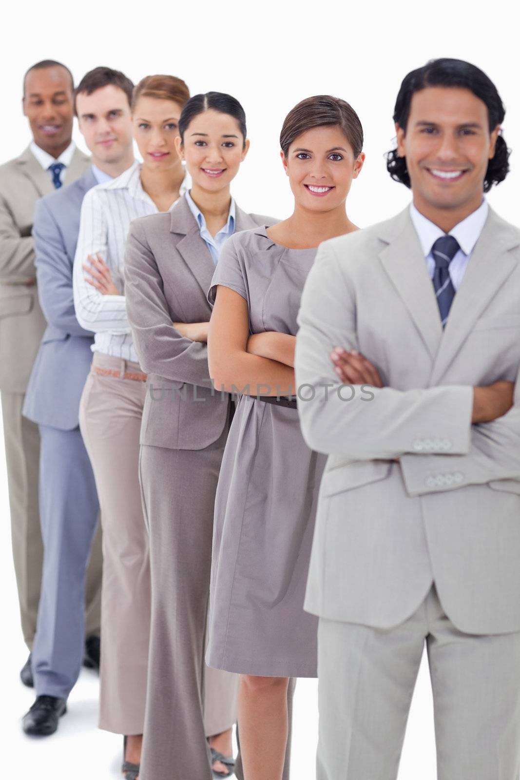 Close-up of a business team in a single line crossing their arms with focus on the first woman