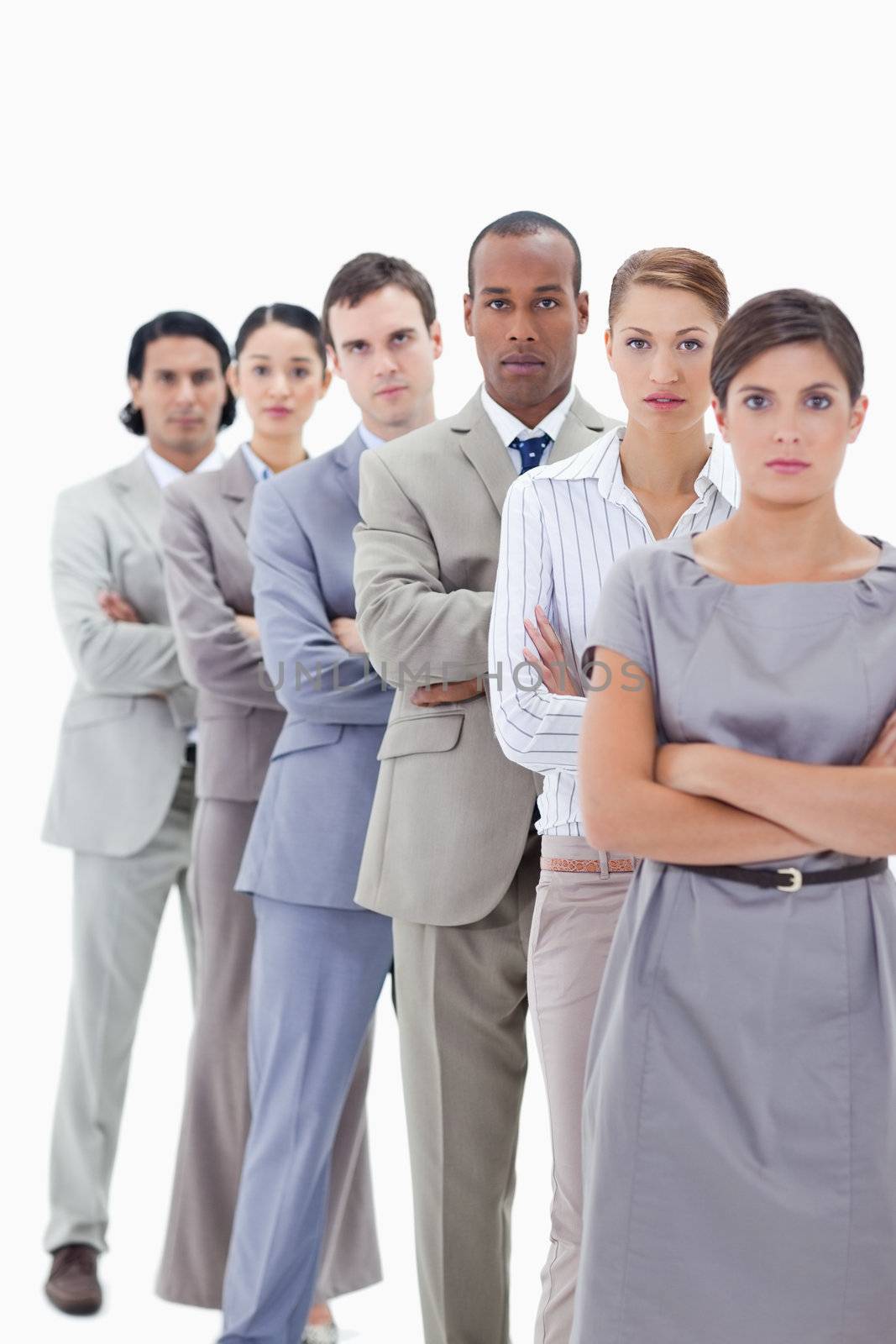 Close-up of a serious business team crossing their arms in a single line against white background