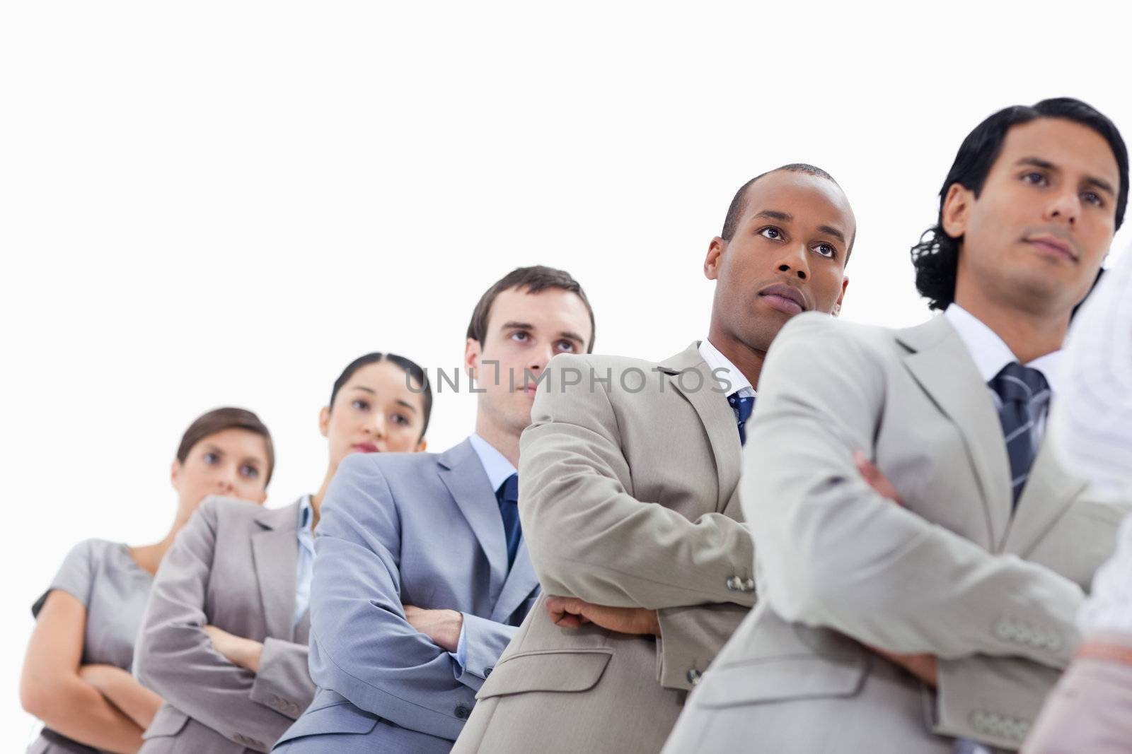 Low-angle shot of a business team crossing their arms in a single line against white background