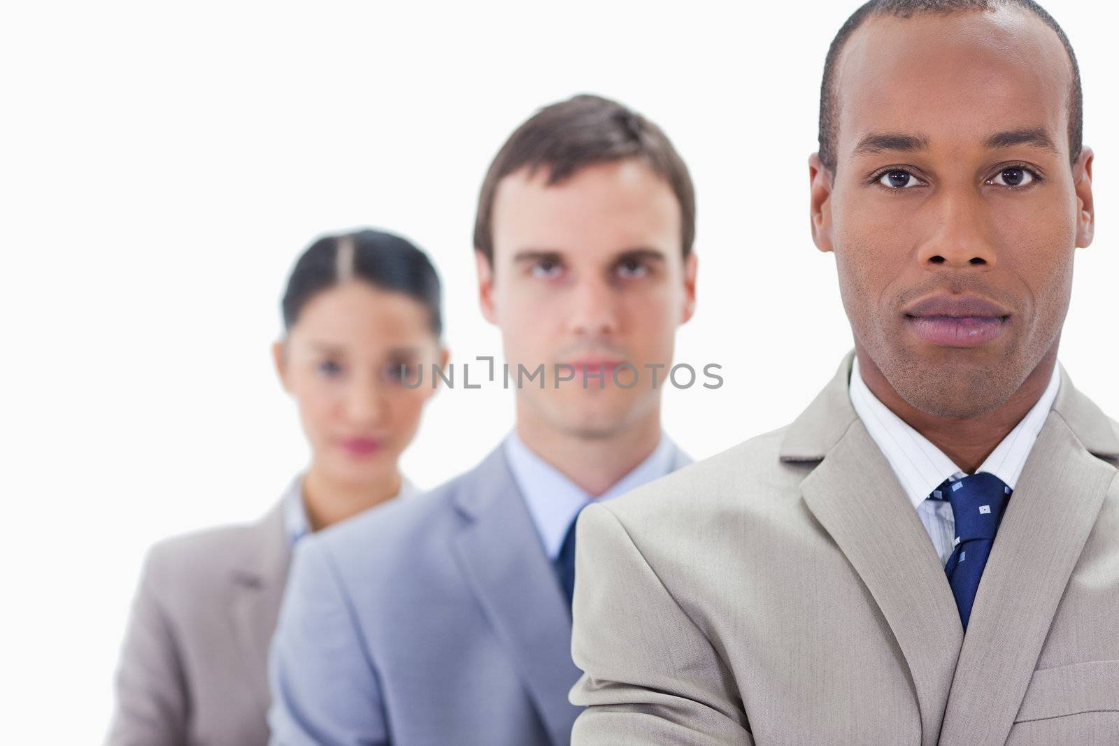 Big close-up of a business team in a single line looking straight with focus on the first man