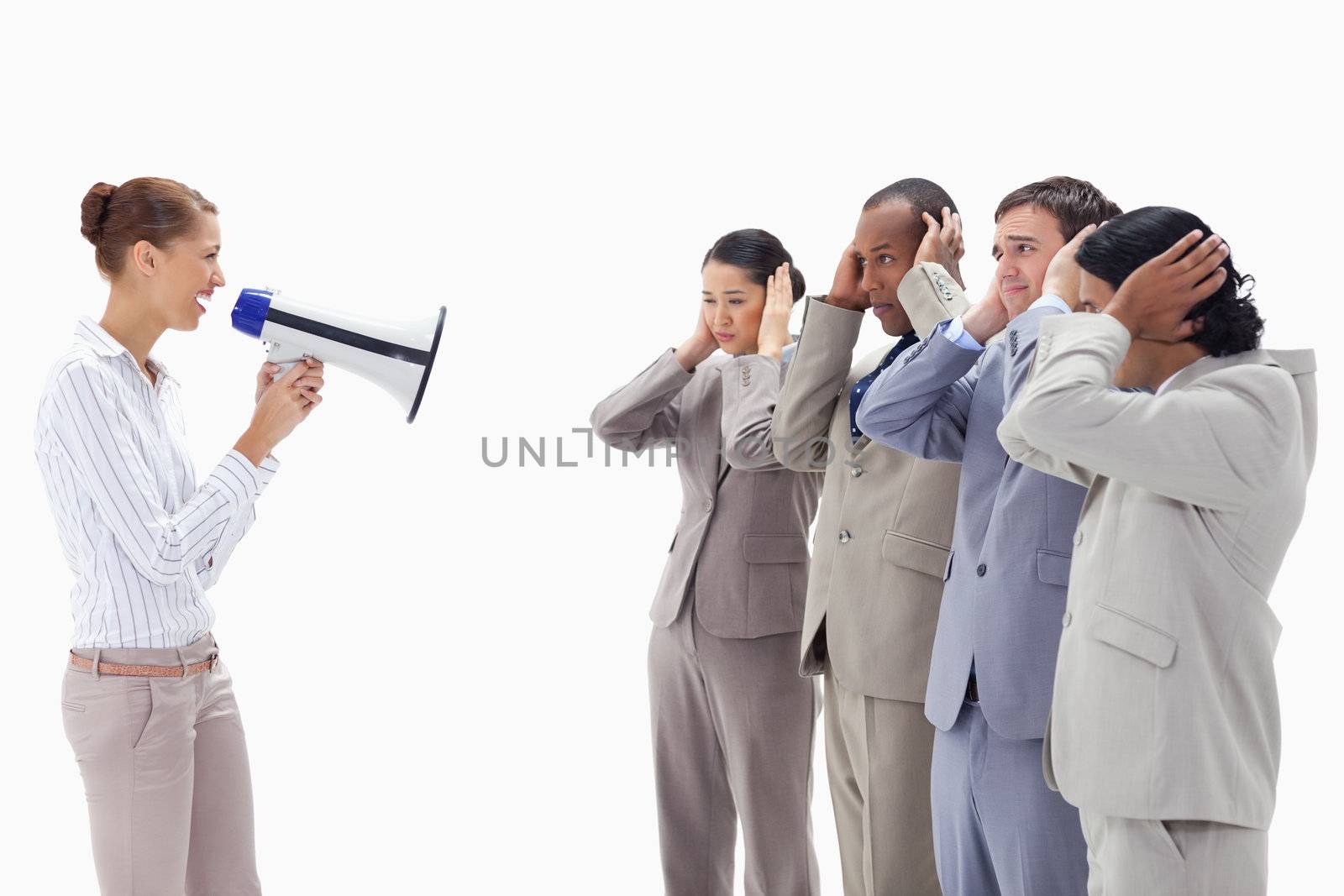 Woman yelling happily through a megaphone at business people with their hands on their ears 
