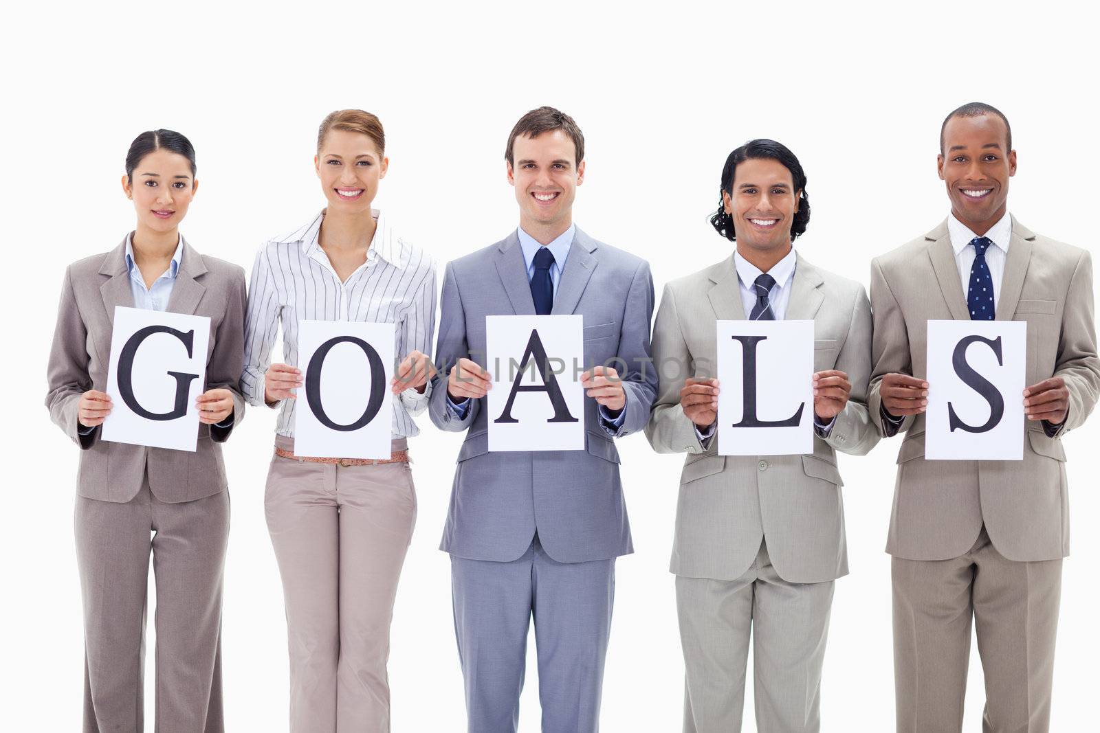 Happy business team holding the letters of GOALS against white background