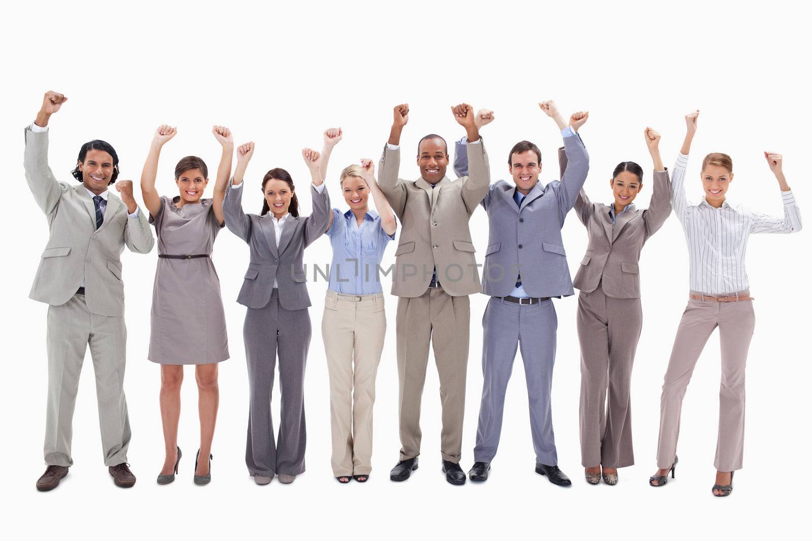 Happy business team raising their arms against white background